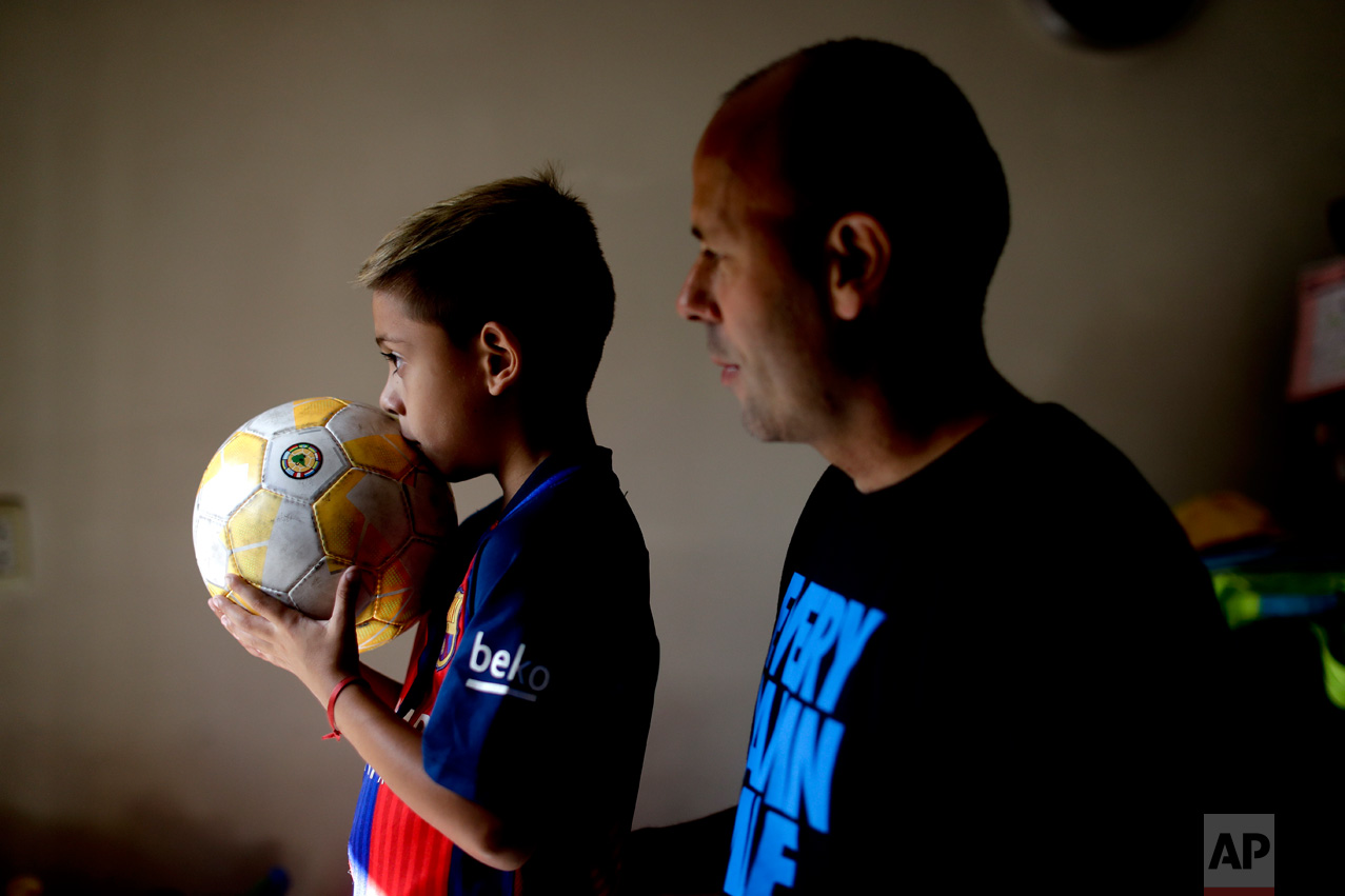 In this Jan. 25, 2017 photo, young soccer player Benjamin Palandella stands with his father Gaston at their home in Buenos Aires, Argentina. "Benjamin is very shy, but he transforms himself on the field," his father said. (AP Photo/Natacha Pisarenko)