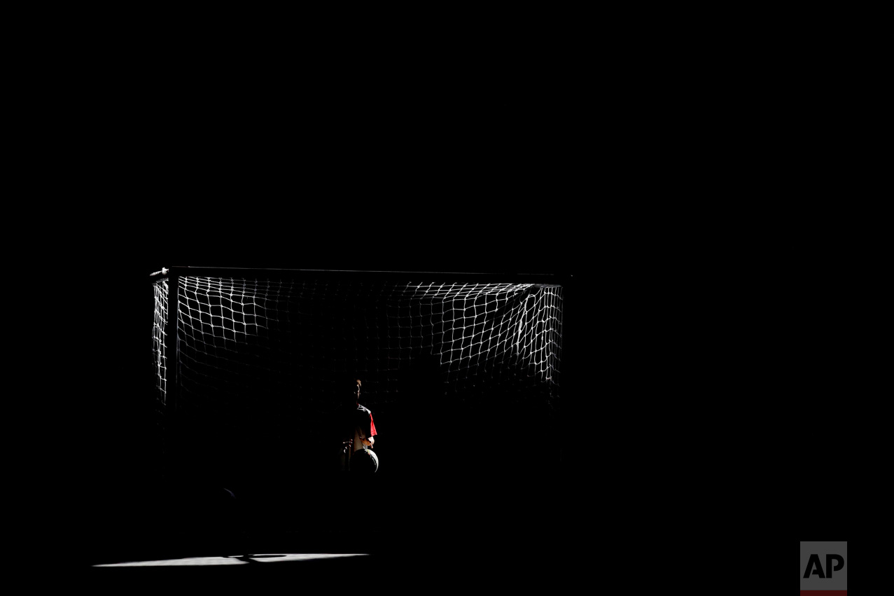 In this March 18, 2017 photo, a player for Club Social Parque catches the ball at the net during a match at the youth soccer academy in a working class neighborhood of Buenos Aires, Argentina. "I often thought about Parque when I needed to resolve a situation on the field," said Cesar Lapaglia, a former professional player for Boca Juniors and Spain's Tenerife, who played at Parque as a youth. "I'd have these flashbacks of advice from the coach." (AP Photo/Natacha Pisarenko)