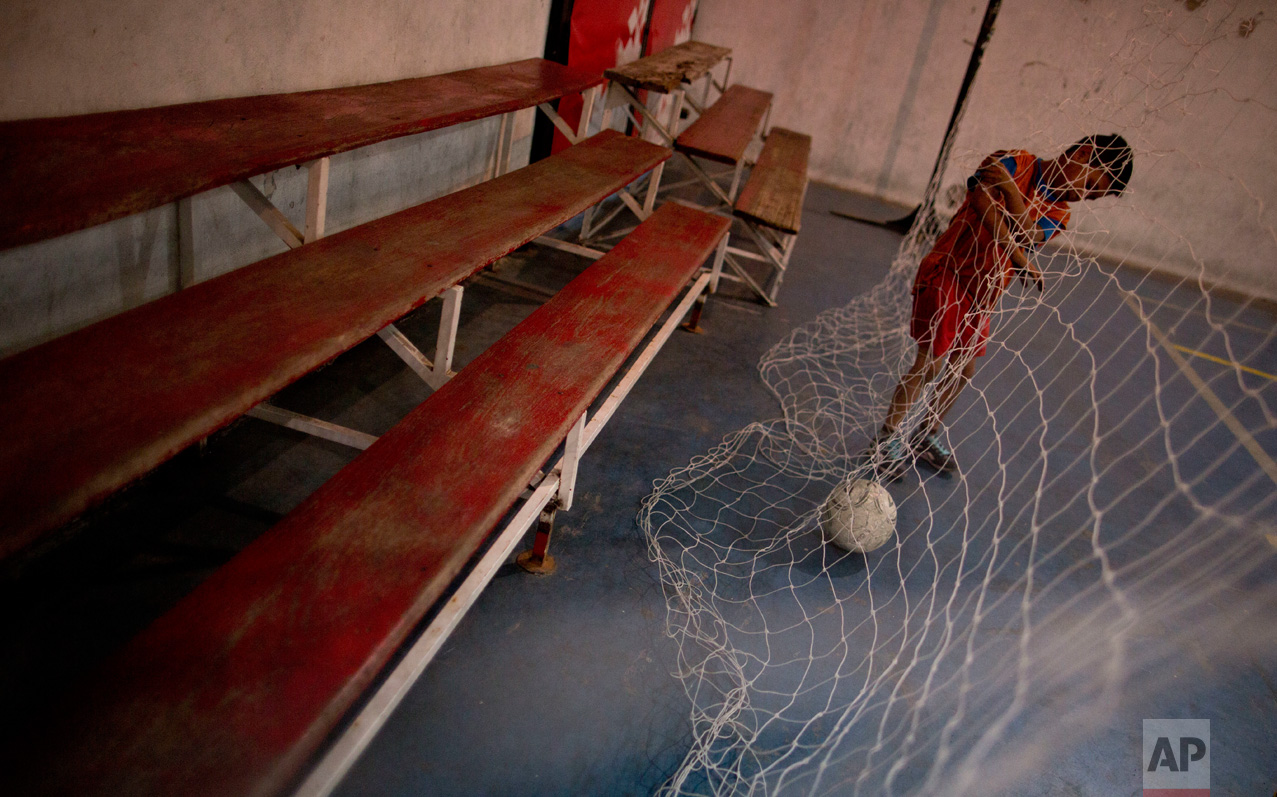 In this Nov. 11, 2016 photo, a young player collects the ball in the net during a training game at youth soccer academy Club Social Parque in a working class neighborhood of Buenos Aires, Argentina. Former players say the secret to Parque is the eye of scout Ramon Maddoni for spotting young talent and his insistence on practicing skill sets in reduced spaces and imperfect surfaces where kids learn how to react faster, giving them a competitive advantage when they eventually reach large professional fields. (AP Photo/Natacha Pisarenko)
