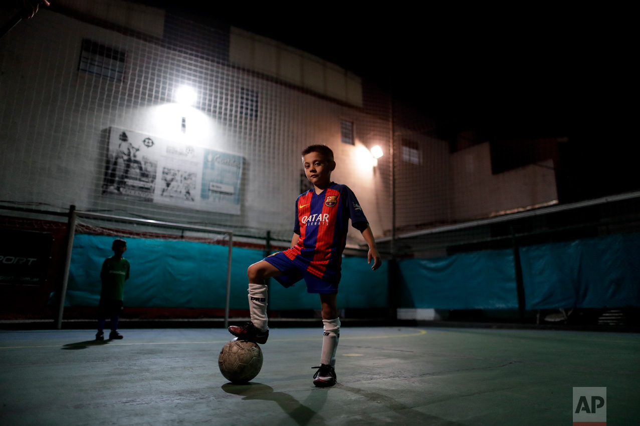 In this Nov. 11, 2016 photo, Benjamin Palandella poses for a portrait wearing his Barcelona shirt after a training session in Buenos Aires, Argentina. Palandella's coach Ramon Maddoni said "Benjamin is different from the group. He can pass with his back turned, he uses both legs." (AP Photo/Natacha Pisarenko)