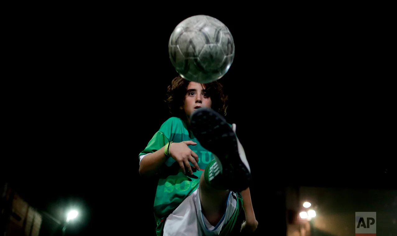 In this Nov. 11, 2016 photo, Thiago "Coco" Perugini controls the ball in Buenos Aires, Argentina. Perugini is one of the top young players at the youth soccer academy Club Social Parque, and has been invited to play with kids two years older than him. (AP Photo/Natacha Pisarenko)