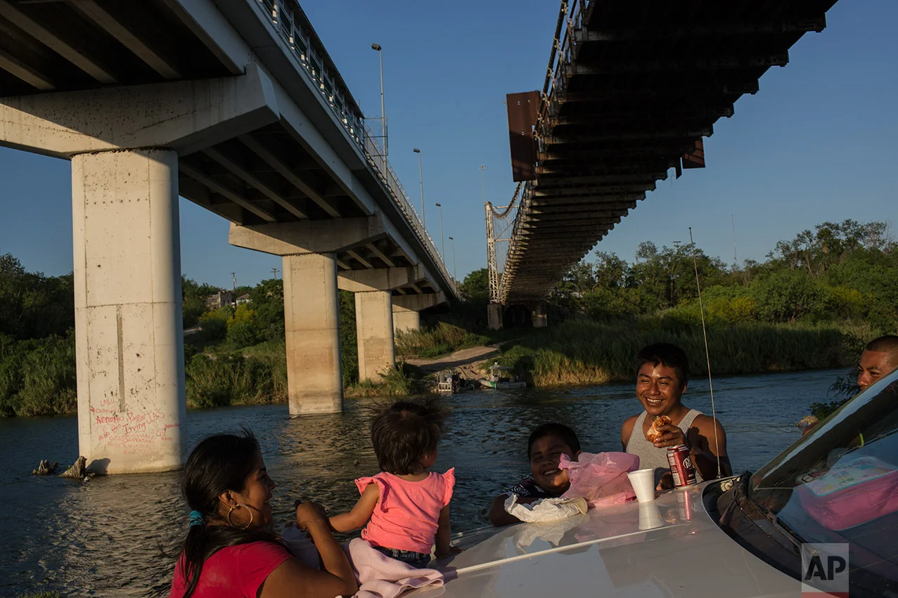 A family enjoys a picnic on the banks of the Rio Grande river in Miguel Aleman, Tamaulipas state, Mexico, Wednesday, March, 22, 2017, located across the river from Roma, Texas. (AP Photo/Rodrigo Abd)