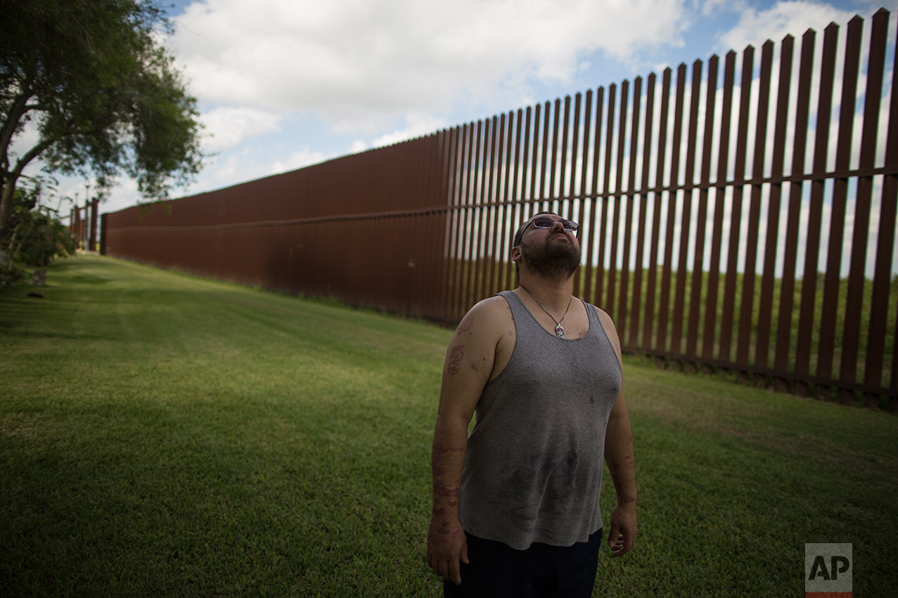 U.S. citizen Antonio Reyes stands by the U.S.-Mexico border fence where his home's located in Brownsville, Texas, Wednesday, March 22, 2017. (AP Photo/Rodrigo Abd)