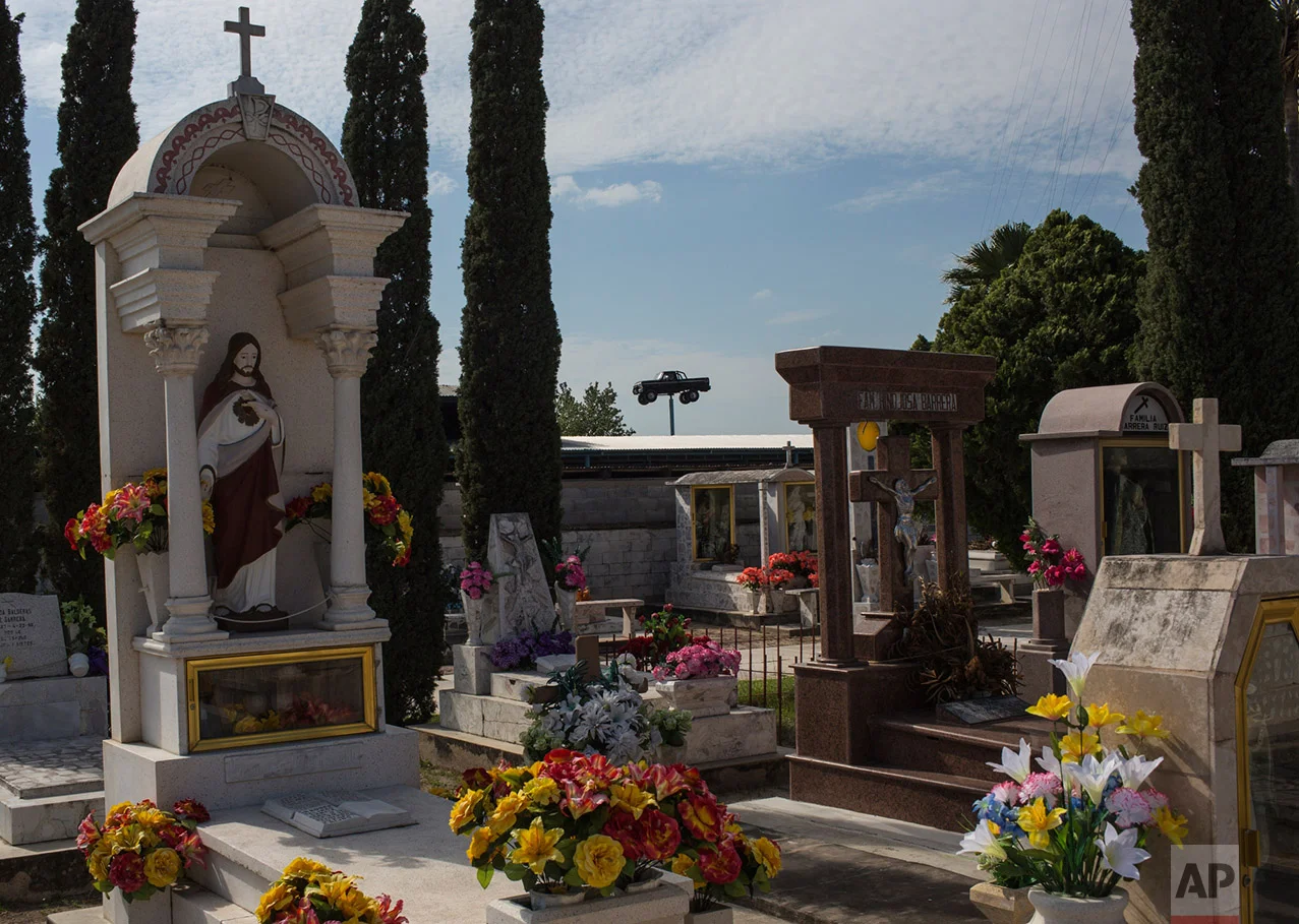 A truck advertising an auto body repair shop is seen behind the cemetery in Los Guerra, Tamaulipas, Mexico, Thursday, 23, 2017. (AP Photo/Rodrigo Abd)