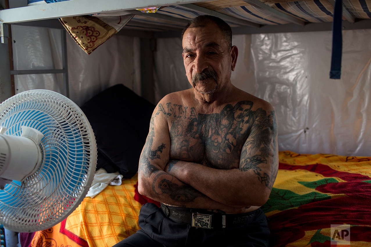 Mexican migrant Juan Parras, 65, covered in tattoos, poses for a portrait in the dormitory at the migrant shelter "Senda de Vida" in Reynosa, Mexico, Wednesday, March 22, 2017. Parras said he was deported one year ago from California, where he left behind three sons, and he plans to try to return but it's more difficult now to get past U.S. security. Regarding the proposed border wall, Parras said "Mexico is not going to pay for the wall." (AP Photo/Rodrigo Abd)