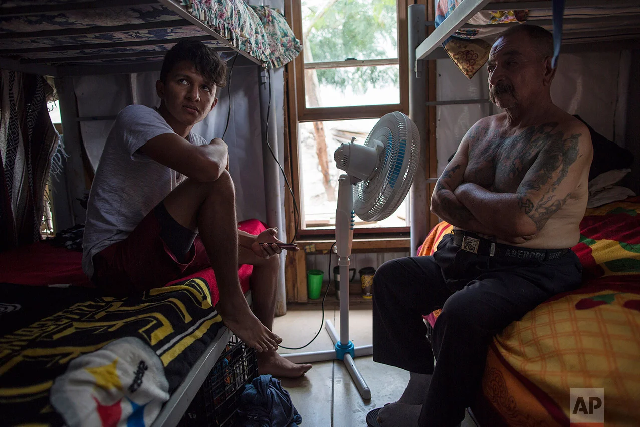 Migrants Juan Parras, 65, right, and Junior Matute, 19, rest on their beds at the migrant shelter "Senda de Vida" in Reynosa, Mexico, Wednesday, March, 22, 2017. Matute said his brother was deported from the United States to Honduras and then murdered in February 2016. “I come for a reason. It’s not like one day I just decided to leave my country,” he says. Parras said he was deported one year ago from California, where he left behind three sons, and that he plans to try to return. (AP Photo/Rodrigo Abd)