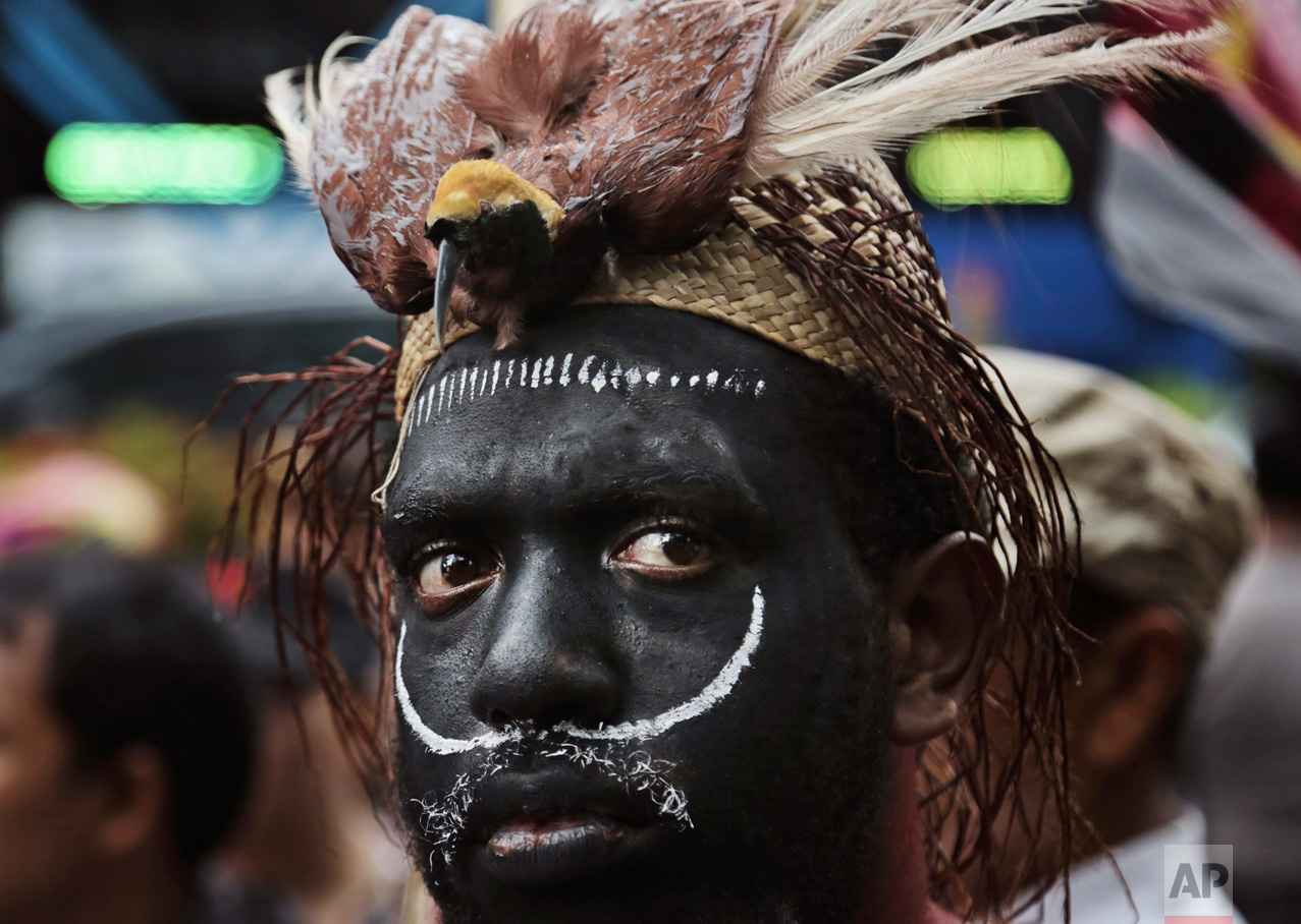 A Papuan activist with traditional headwear which includes a stuffed bird of paradise attends a protest against U.S. mining giant Freeport-McMoRan Copper & Gold Inc. in Jakarta, Indonesia, Monday, March 20, 2017. A group of activists staged the protest demanding the New Orleans-based mining company close its mine in Papua province saying that it siphons off the region's wealth and gives it little in return. (AP Photo/Achmad Ibrahim)