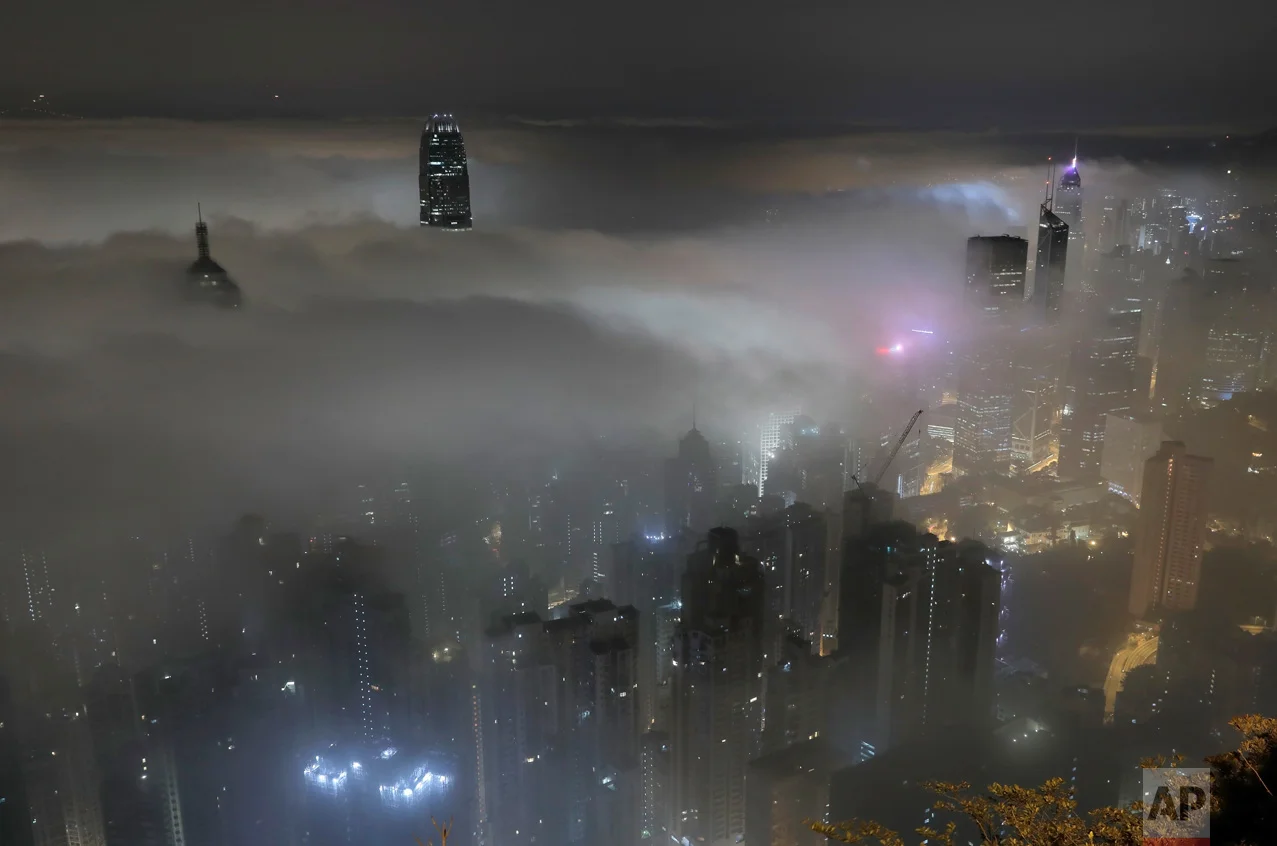 High-rise buildings are partly covered by heavy fog in Hong Kong's Victoria Harbour on Monday, March 20, 2017. Fog blanketing the city is common in spring and can greatly affect shipping and aviation. (AP Photo/Vincent Yu)