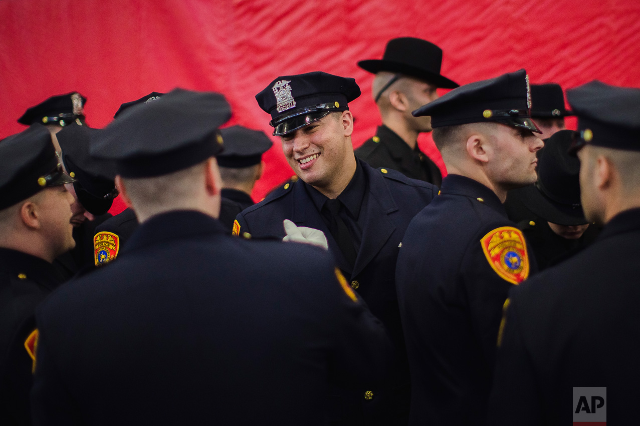 Matias Ferreira, center, celebrates with his colleagues during their graduation from the Suffolk County Police Department Academy at the Health, Sports and Education Center in Suffolk, N.Y., Friday, March 24, 2017. (AP Photo/Andres Kudacki)