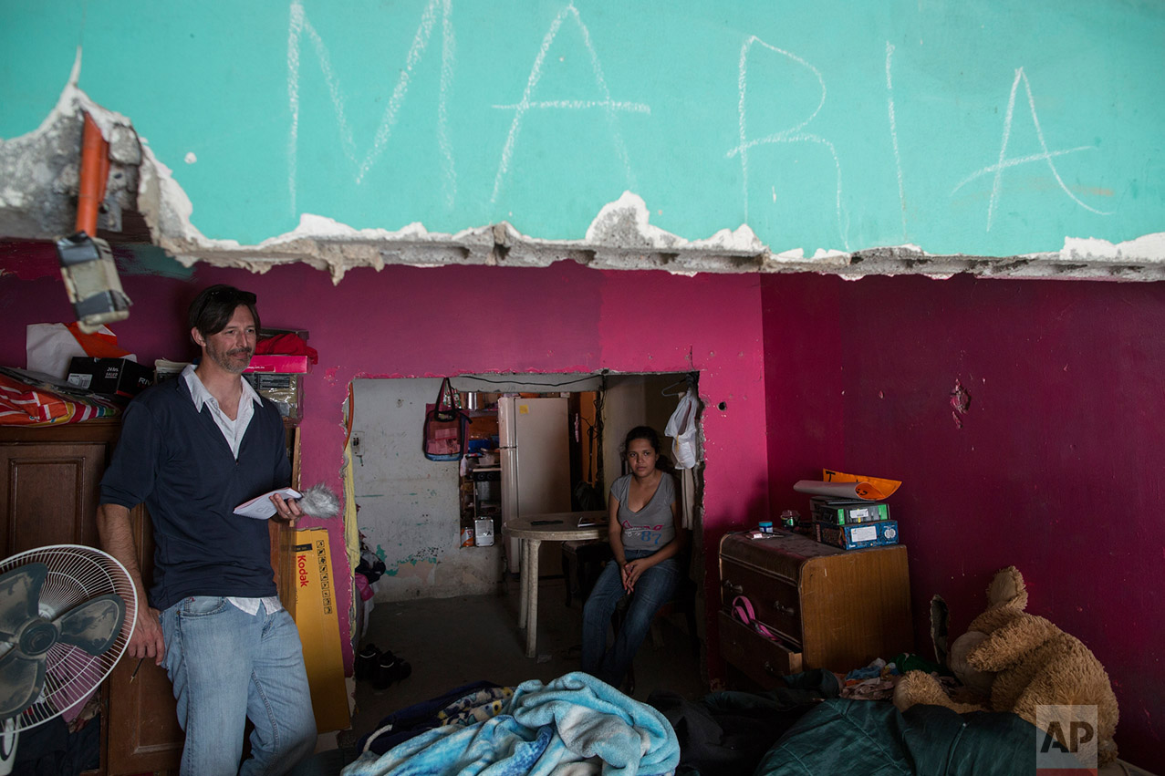 AP journalist Christopher Sherman interviews Maria Paula Esteban Cruz, right, and her mother, Jesus Esteban Cruz (not in the picture), inside their home in Reynosa, Mexico, Wednesday, March 22, 2017, across the border from McAllen, Texas. (AP Photo/Rodrigo Abd)