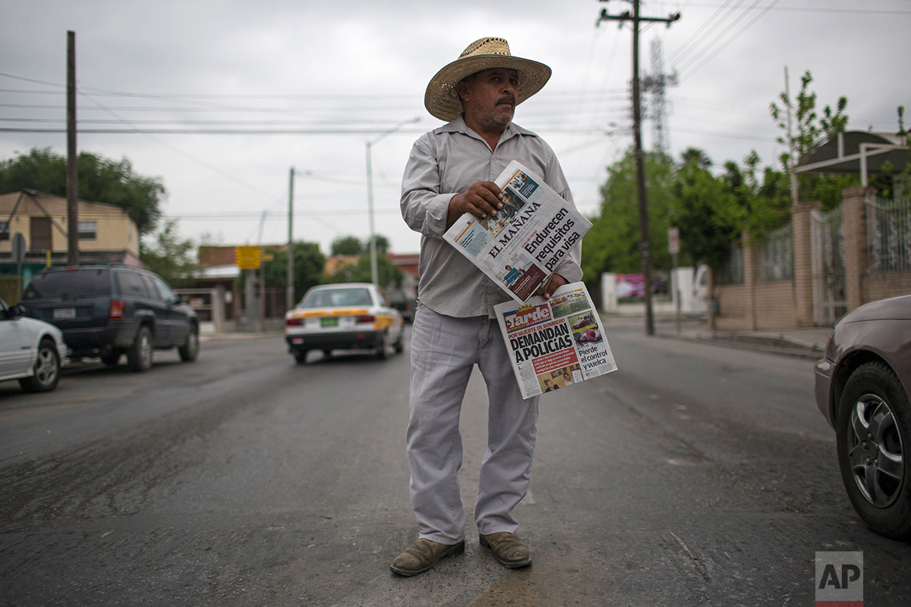  A man sells newspapers in downtown Nuevo Laredo, Tamaulipas state, Mexico, across the border from Laredo in the U.S, Friday March 24, 2017. Th headlines read in Spanish 'visa requirements get harder' top, and 'policemen are sued', bottom.(AP Photo/R