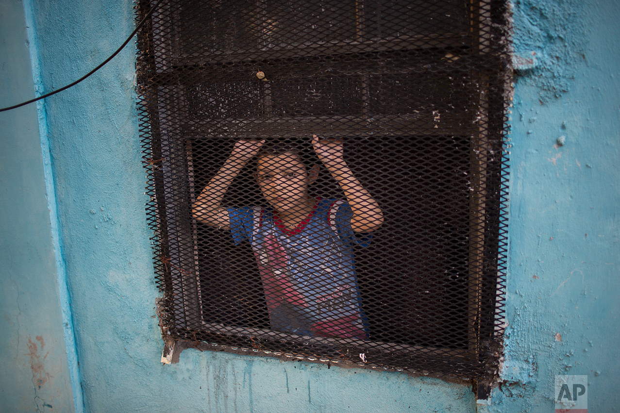  A boy peeks out of the window of his house in Nuevo Laredo, Tamaulipas state, Mexico, across the border from Laredo in the U.S, Friday March 24, 2017.(AP Photo/Rodrigo Abd) 