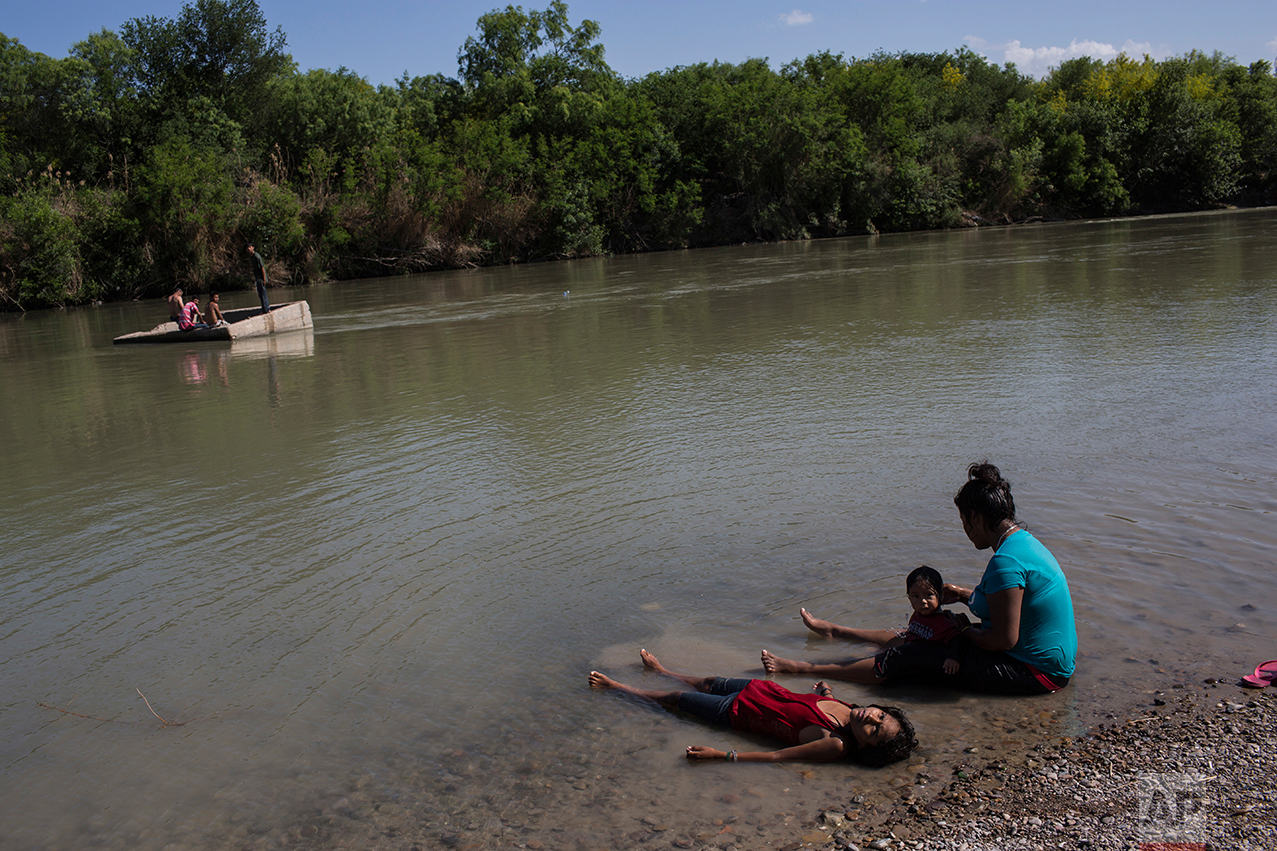  People cool off in the Rio Grand river, or Rio Grande and Rio Bravo in Spanish, in Nuevo Laredo, Tamaulipas state, Mexico, Saturday, March 25, 2017, across the border from Laredo, Texas. (AP Photo/Rodrigo Abd) 