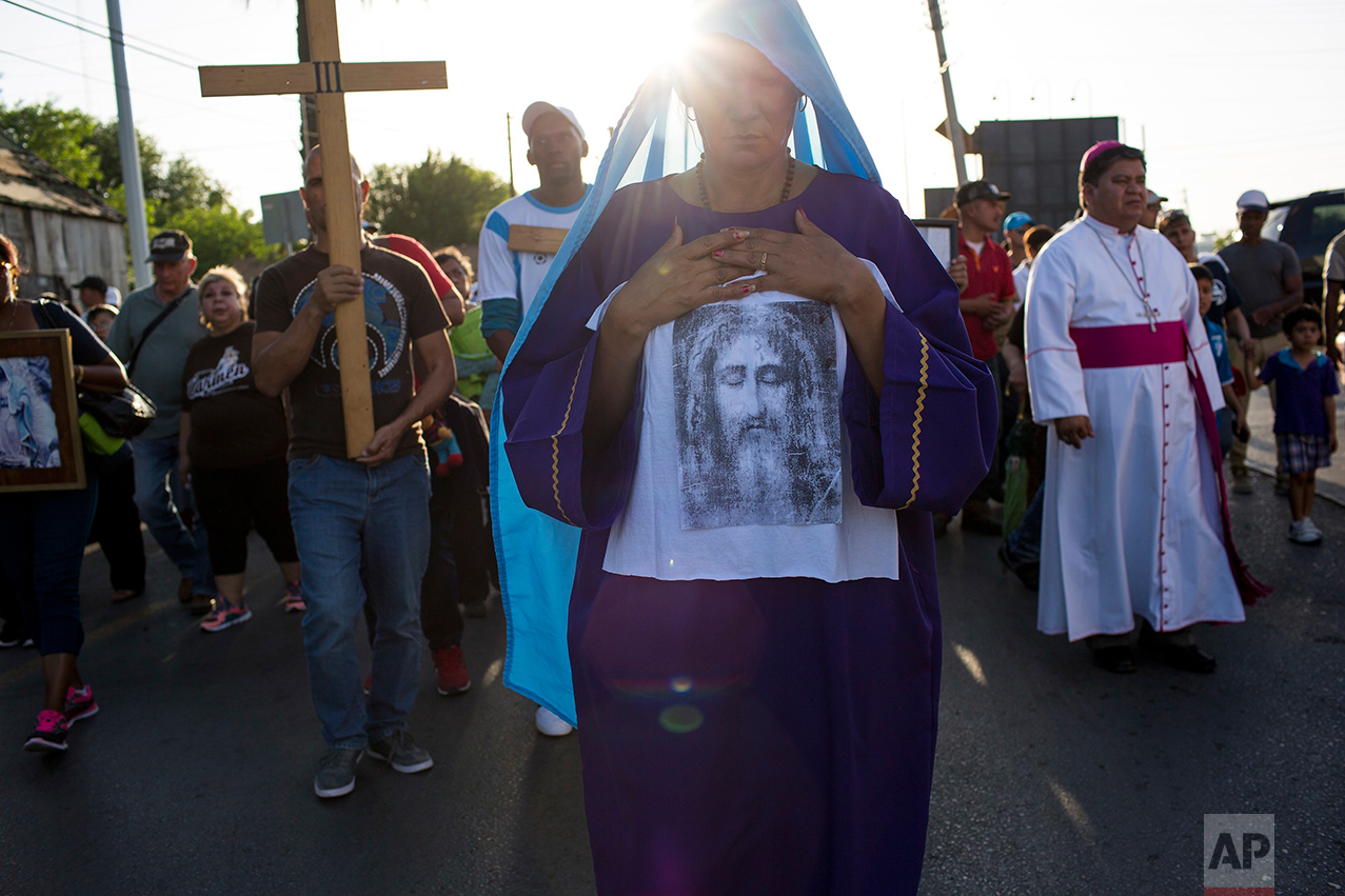 Cuban Idenia Vidal leads a religious procession adapted to reflect the plight of immigrants, in Nuevo Laredo, Tamaulipas state, Mexico, Friday, March, 24, 2017, across the border from Laredo, Texas. (AP Photo/Rodrigo Abd)