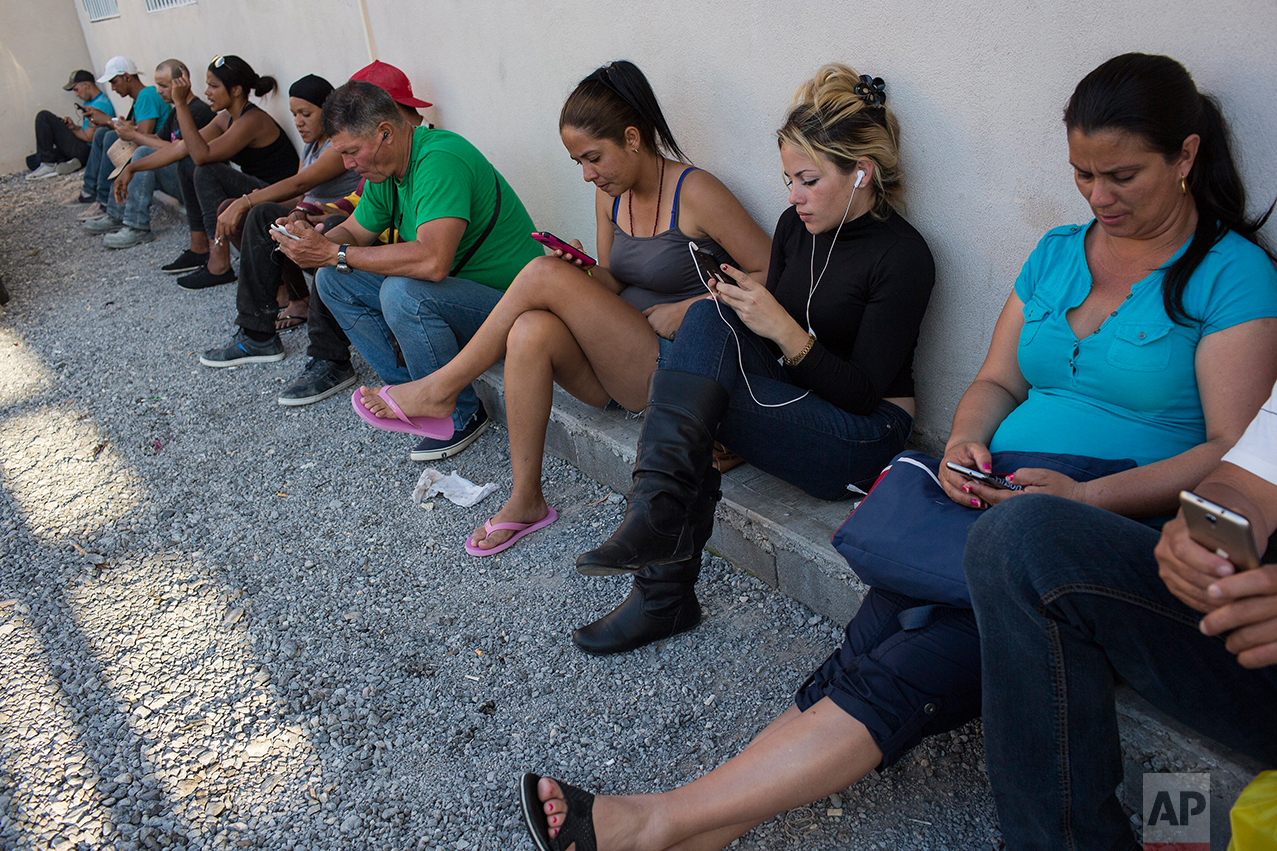 Cubans check their cell phones inside the migrant shelter "Casa del Migrante" in Nuevo Laredo, Tamaulipas state, Mexico, Saturday, March 25, 2017, across the border from Laredo, Texas. The shelter limits migrants to one hour of cell phone usage, for security reasons. ?? (AP Photo/Rodrigo Abd)