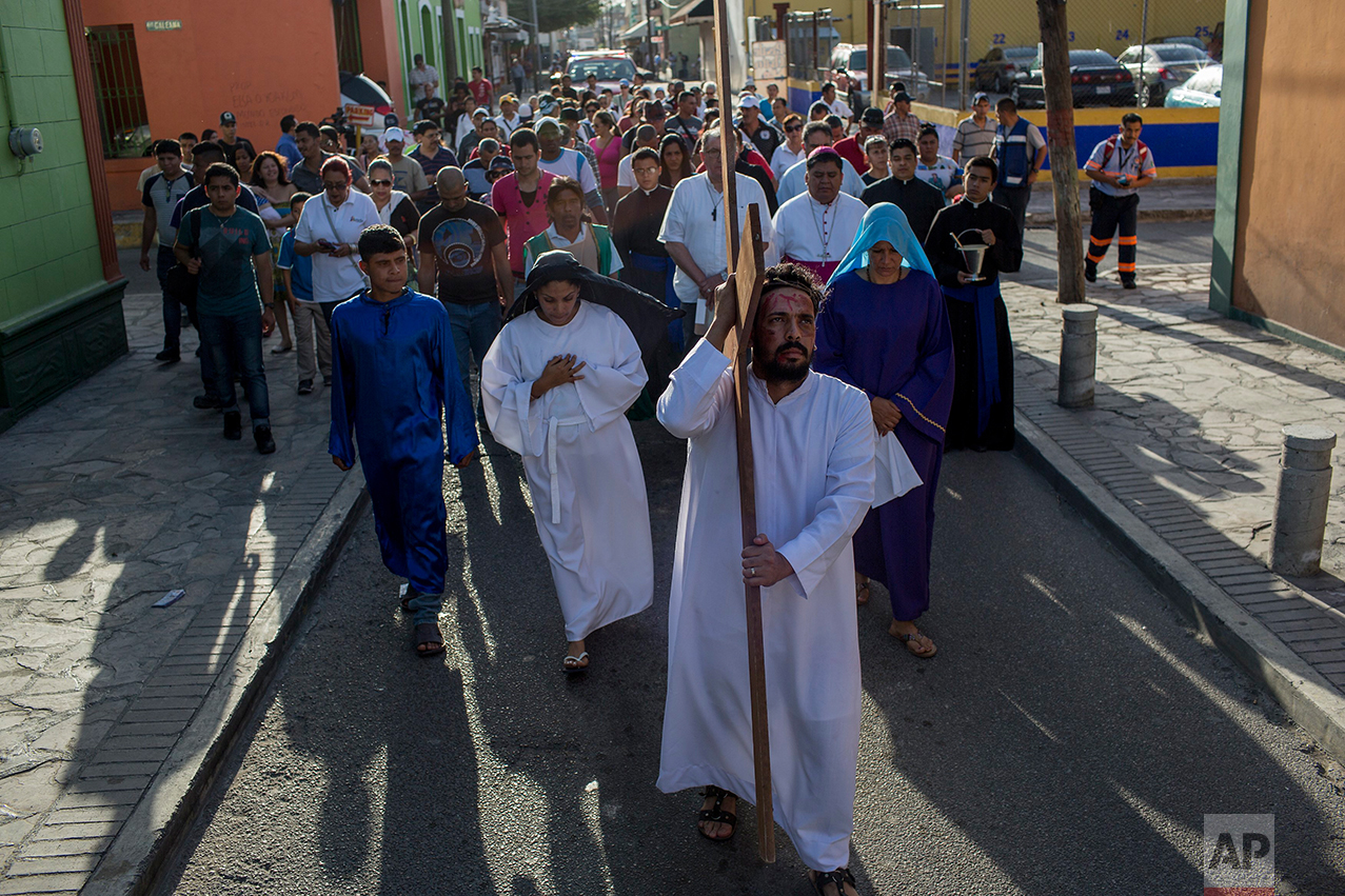Cuban migrant Rudy Rivero leads a religious procession, adapted to reflect the plight of immigrants, in Nuevo Laredo, Tamaulipas state, Mexico, Friday, March 24, 2017, across the border from Laredo, Texas. (AP Photo/Rodrigo Abd)