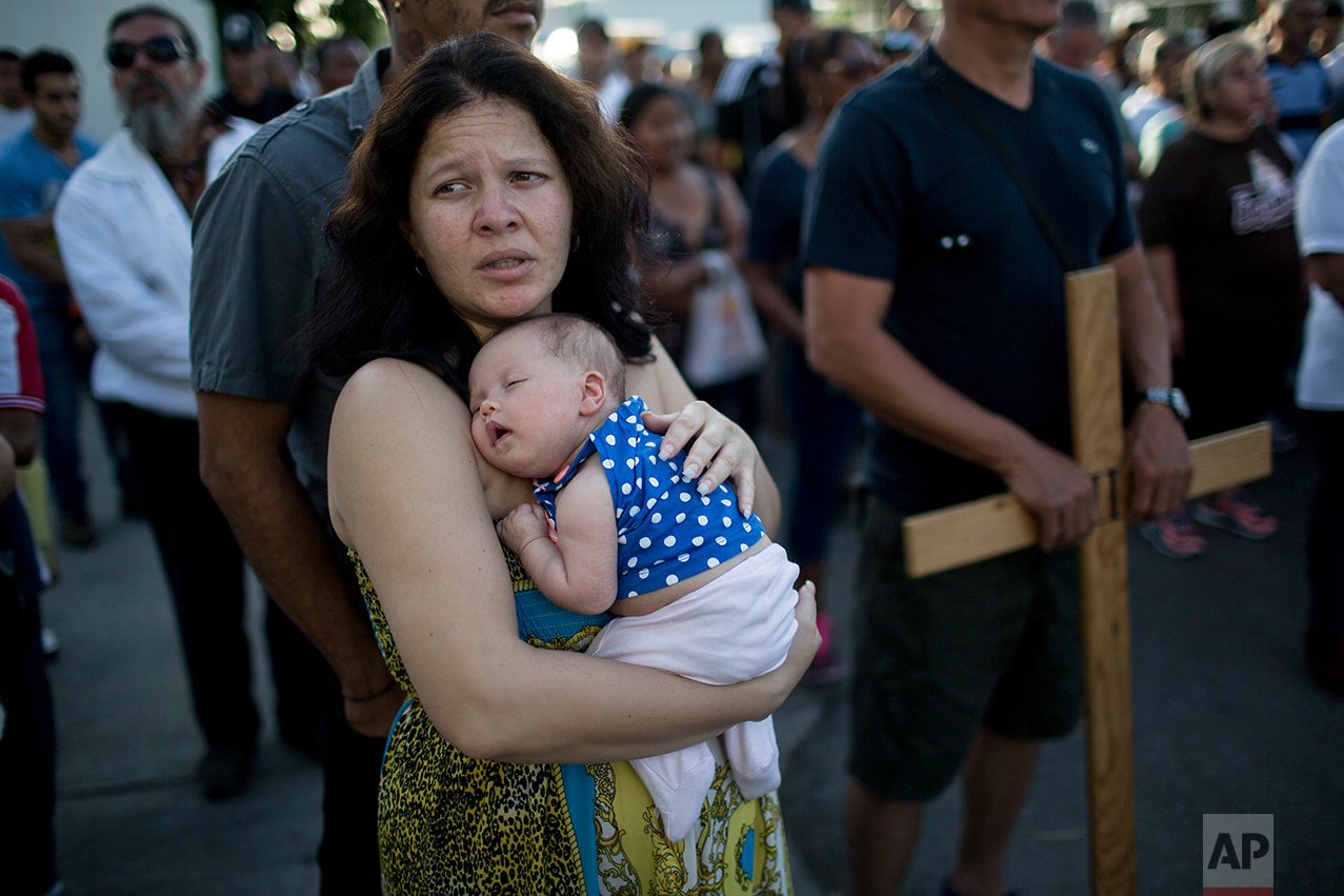 Cuban Elaide Vilchez carries her one-month-old daughter Emily Melania Garcia during a religious procession adapted to reflect the plight of immigrants, in Nuevo Laredo, Tamaulipas state, Mexico, Friday, March 24, 2017, across the border from Laredo, Texas. (AP Photo/Rodrigo Abd)