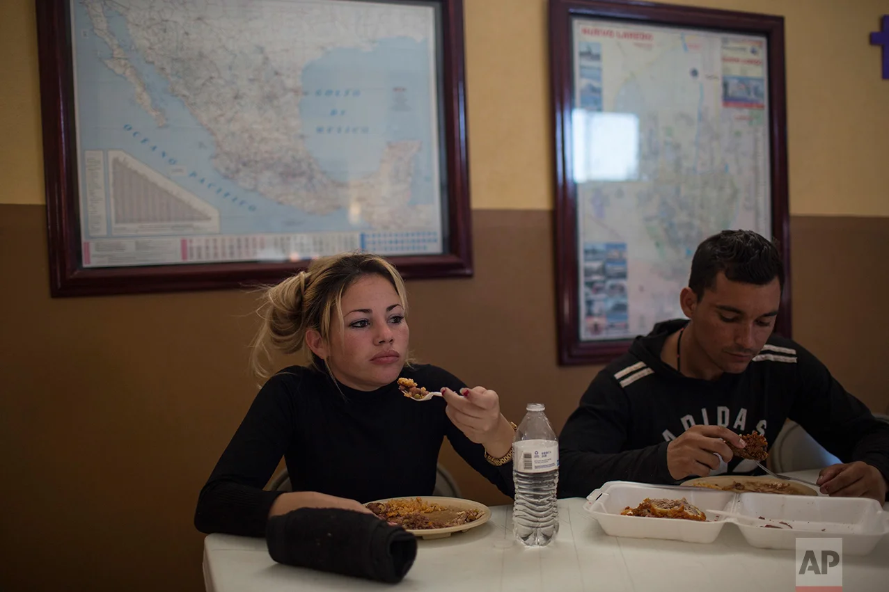 Cuban migrants Chaday Sanchez and her boyfriend Rodolfo Munoz eat dinner at the migrant shelter "Casa del Migrante" in Nuevo Laredo, Tamaulipas state, Mexico, Saturday, March 25, 2017, across the border from Laredo, Texas. (AP Photo/Rodrigo Abd)