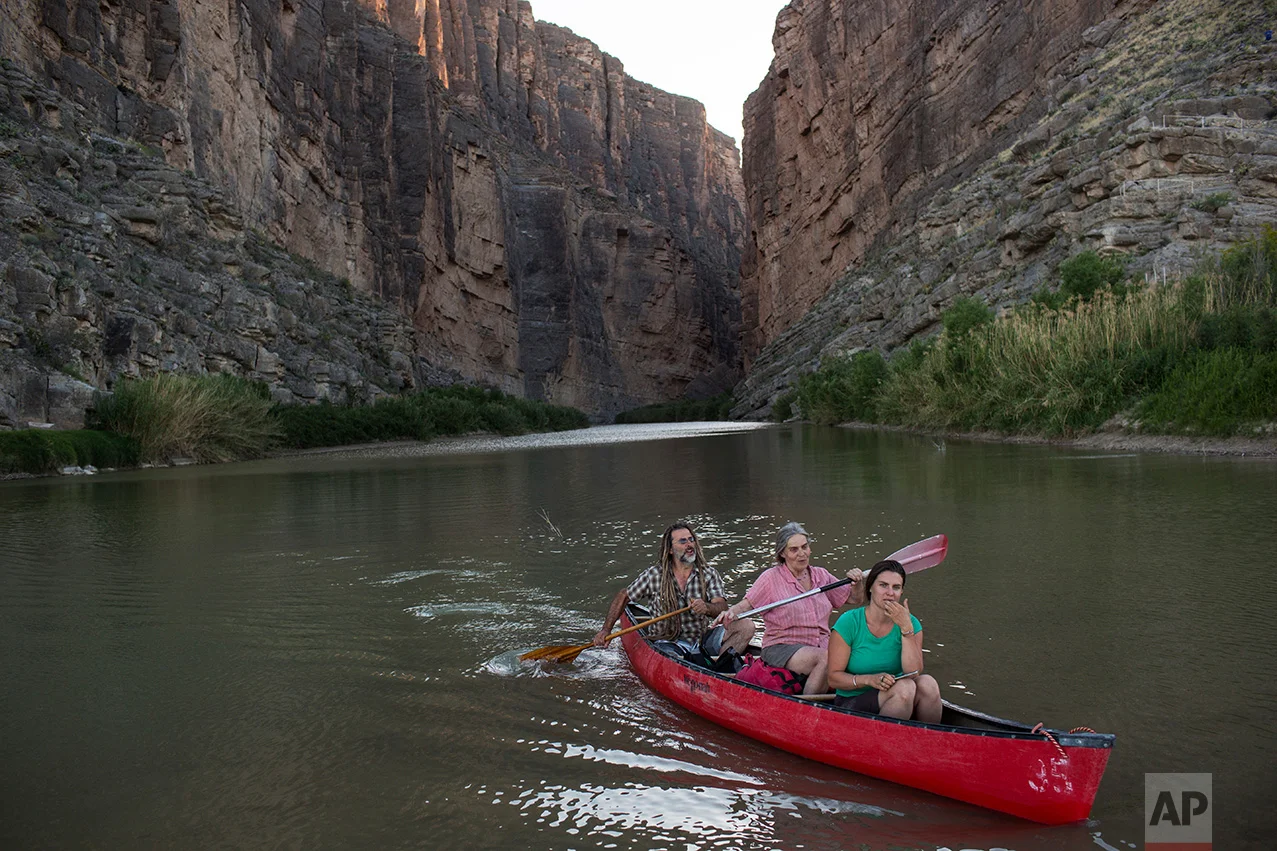 Tourists kayak through Santa Elena Canyon on the Rio Grande river, just feet from a cliff face that is Mexico, left, at Big Bend National Park in Texas, Monday, March 27, 2017. (AP Photo/Rodrigo Abd)