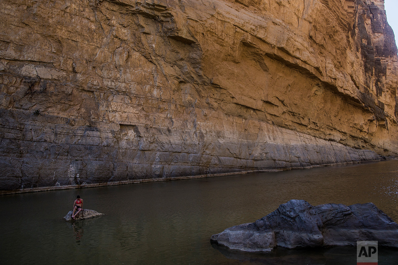  Margaret McCall, a clean energy consultant from Chicago, sits on a rock in Santa Elena Canyon in the Rio Grande river just feet from a cliff face that is Mexico, behind her, as she vacations at Big Bend National Park in Texas, Monday, March 27, 2017