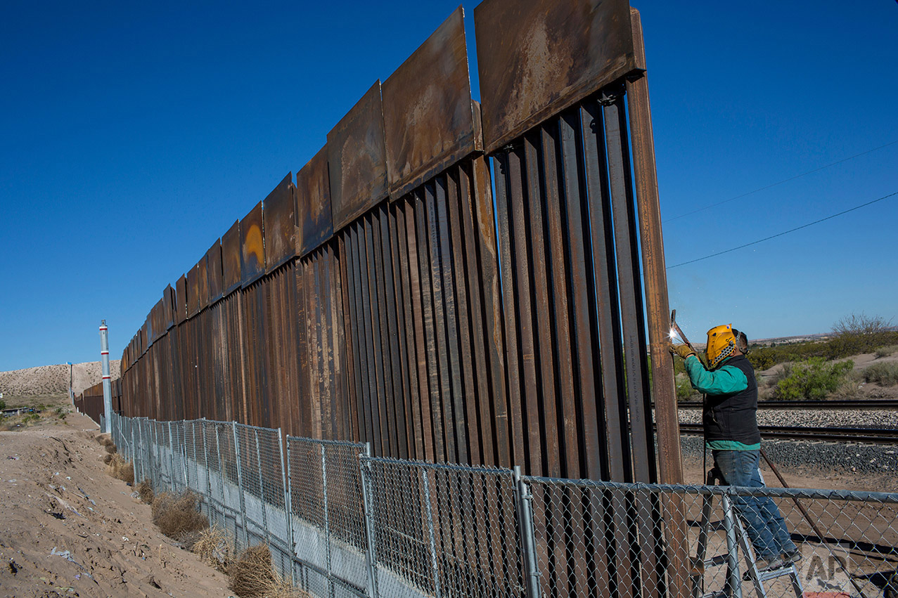  A worker welds a new fence between the Anapra neighborhood of Ciudad Juarez, Mexico, and Sunland Park, New Mexico, Thursday, March 30, 2017. The top three feet or so of the fence, which was planned and started before President Donald Trump's electio