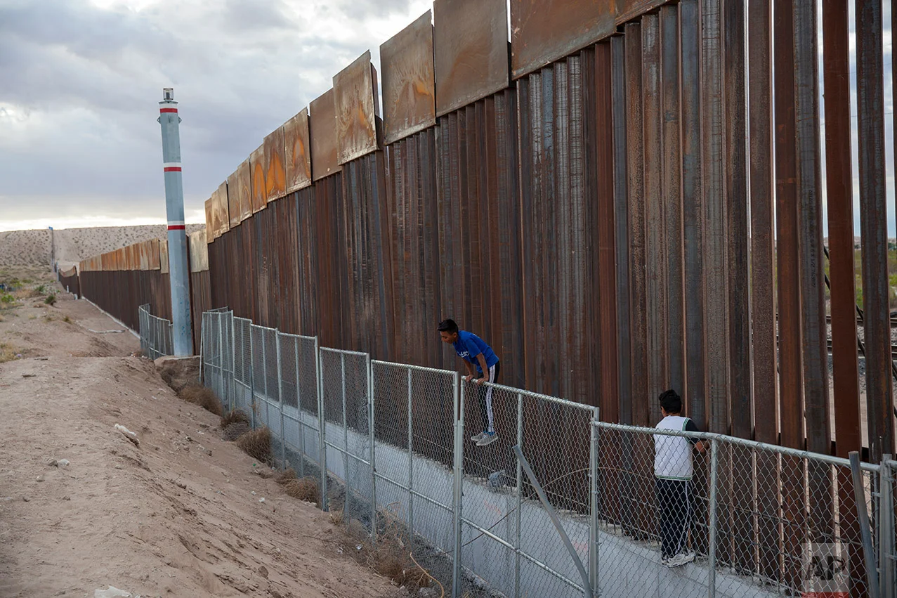 Children play on two fences marking the U.S.-Mexico border, in the Anapra neighborhood of Ciudad Juarez, Mexico, Wednesday, March 29, 2017, across the border form Sunland Park, New Mexico. In Mexico, people have lived and worked in the existing fence's shadow for years. That experience has made them dispassionate toward talk of new construction of a larger wall. (AP Photo/Rodrigo Abd)