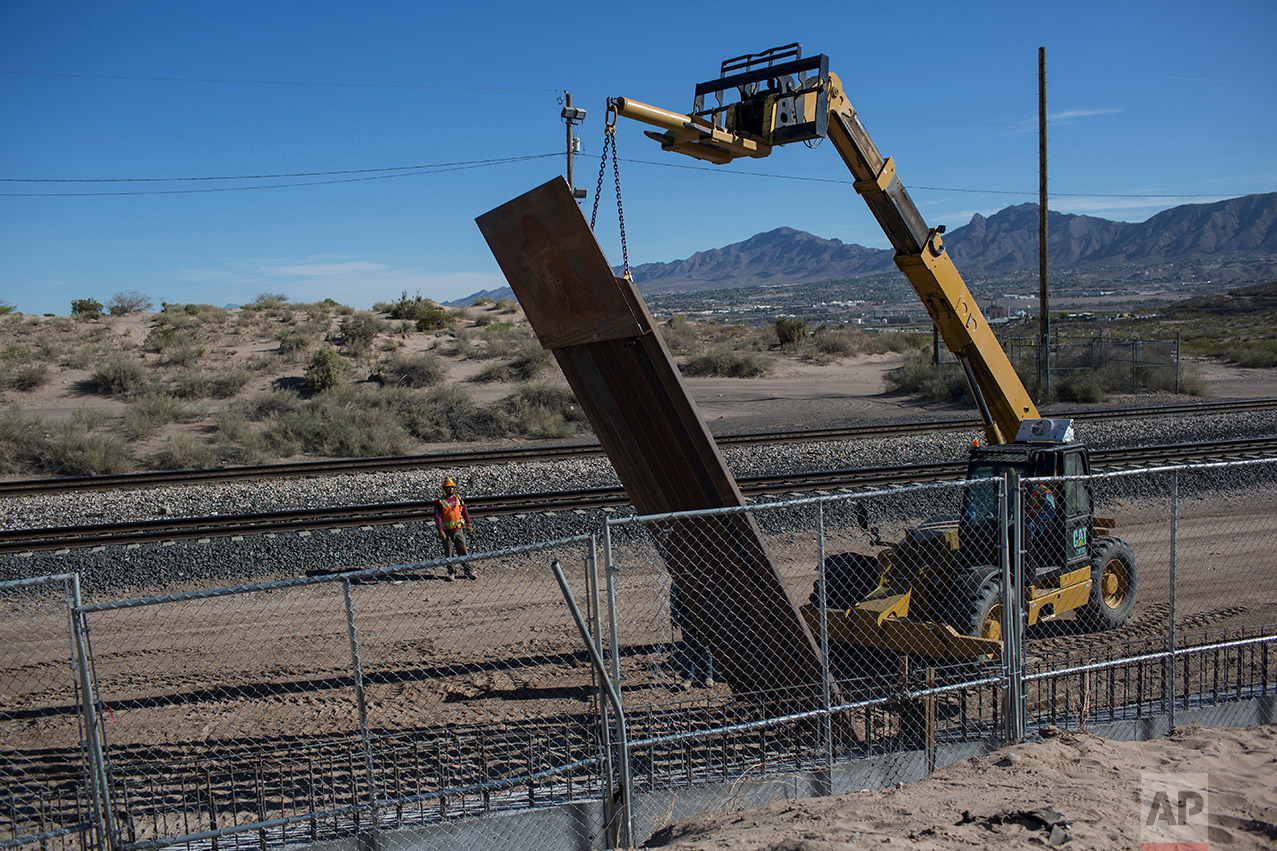  Workers use a crane to lift a segment of a new fence into place on the U.S. side of the border with Mexico, where Sunland Park, New Mexico, meets the Anapra neighborhood of Ciudad Juarez, Mexico, Thursday, March 30, 2017. Residents on the Mexico sid