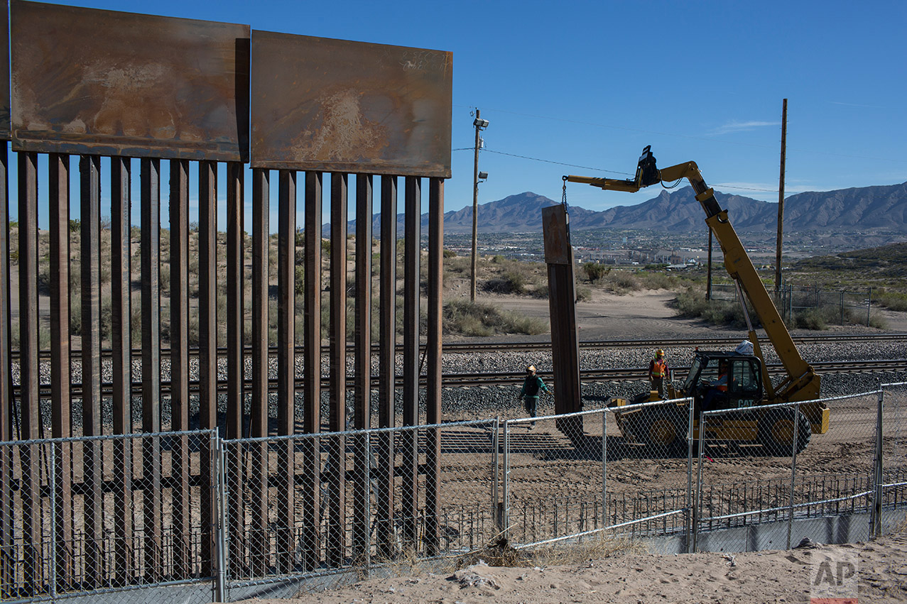  Workers use a crane to lift a segment of a new fence into place on the U.S. side of the border with Mexico, where Sunland Park, New Mexico, meets the Anapra neighborhood of Ciudad Juarez, Mexico, Thursday, March 30, 2017. Residents on the Mexico sid