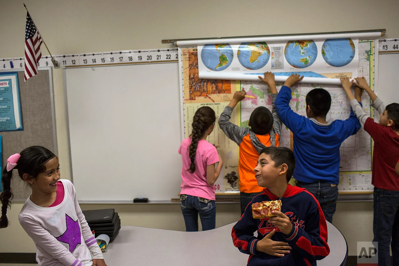 A student eats a slice of pizza during a break in a fourth grade classroom at Columbus Elementary School, in Columbus, New Mexico, Friday, March 31, 2017. (AP Photo/Rodrigo Abd)