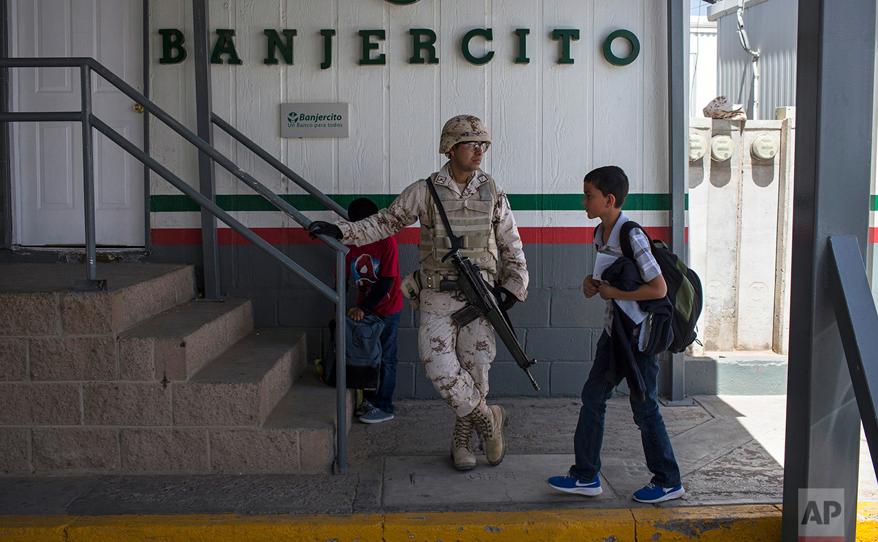  Students from Columbus Elementary School, walk next to a Mexican soldier while crossing  the border from Columbus, New Mexico, US, into Palomas, Mexico, after school, Friday, March 31, 2017. (AP Photo/Rodrigo Abd) 