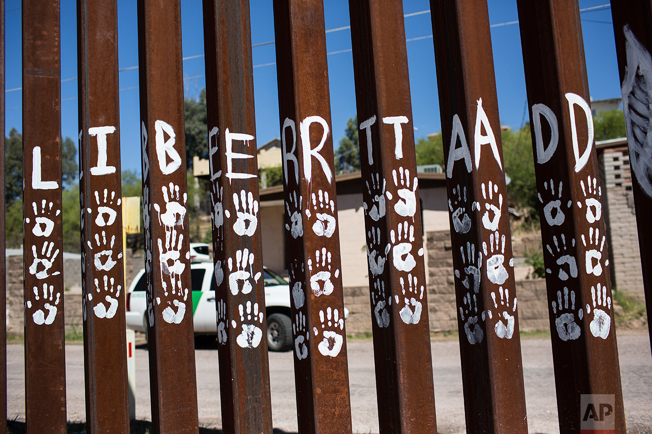  Handprints and the Spanish word for "Liberty" mark slats of the US-Mexico border fence in Nogales, Mexico, Sunday, April 2, 2017. (AP Photo/Rodrigo Abd) 