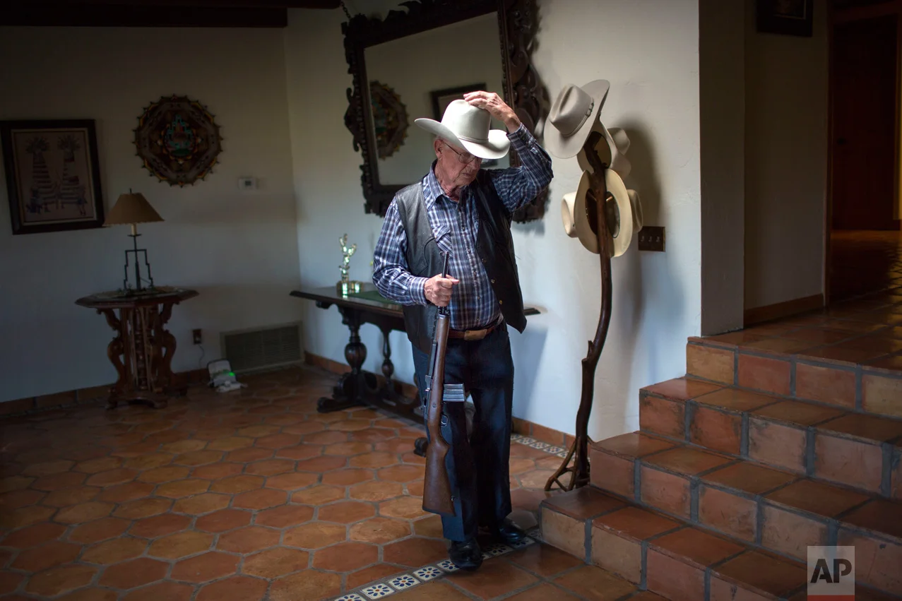 Rancher Jim Chilton puts on his hat before heading out to survey his 50,000-acre ranch in Arivaca, about 80 miles southwest of Tucson, Ariz., Sunday, April 2, 2017. (AP Photo/Rodrigo Abd)