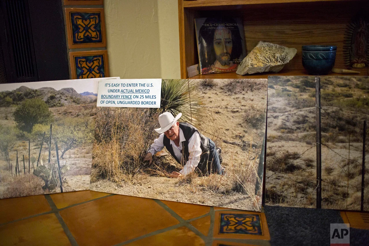 A photo of rancher Jim Chilton showing how easy it is to climb under the existing barbed wire fence on his ranch along the US-Mexico border, is displayed in his home in Arivaca, Ariz., Sunday, April 2, 2017. (AP Photo/Rodrigo Abd)