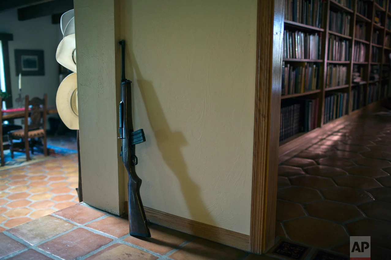 Rancher Jim Chilton's rifle is propped against a wall inside his ranch in Arivaca, Ariz., Sunday, April 2, 2017. (AP Photo/Rodrigo Abd)