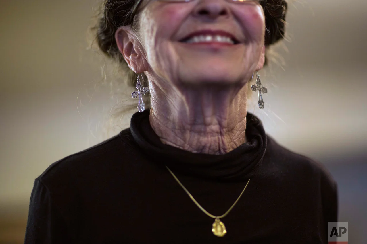 Sue Chilton, the wife of rancher Jim Chilton, dons silver crucifix earrings, as she smiles in their 50,000 acre ranch in Arivaca, Ariz., Sunday, April 2, 2017. (AP Photo/Rodrigo Abd)