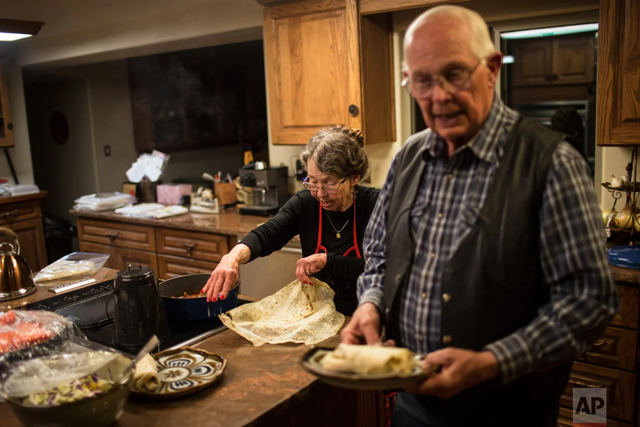 Rancher Jim Chilton prepares dinner with his wife Sue, inside the home of their 50,000 acre ranch in Arivaca, Arizona, Sunday, April 2, 2017. (AP Photo/Rodrigo Abd)