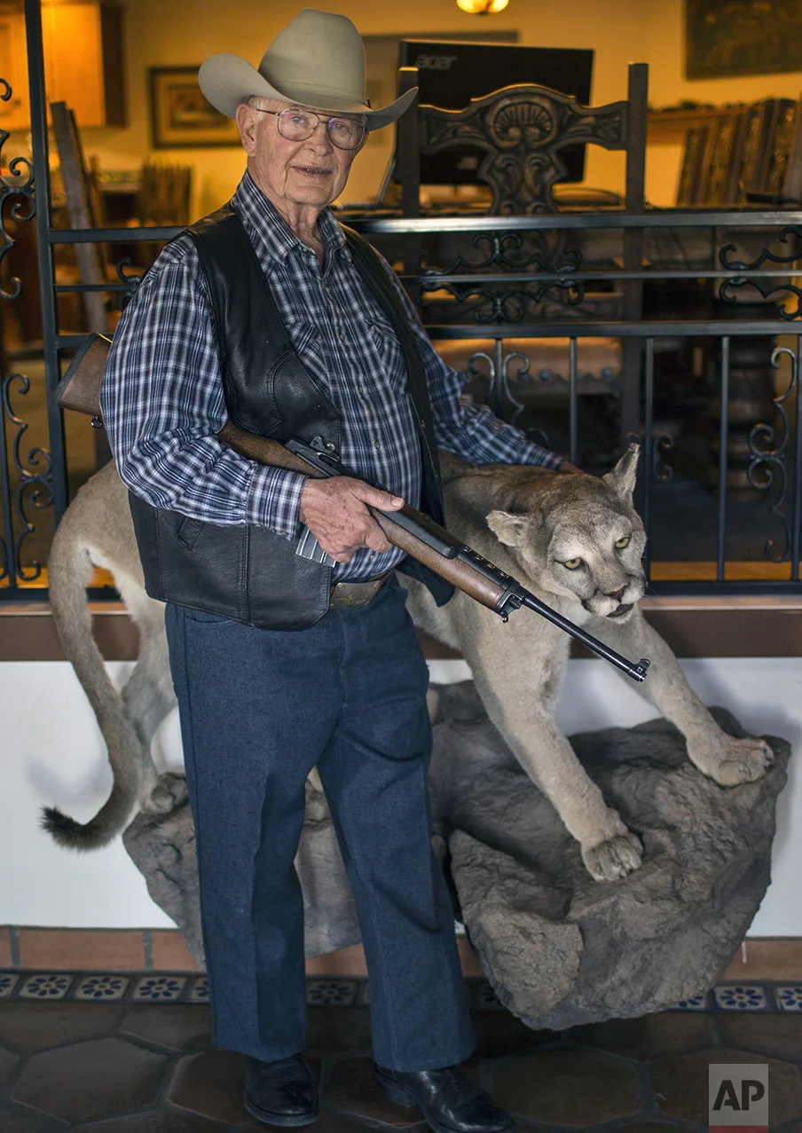 Rancher Jim Chilton poses for a photo next to a taxidermied mountain lion at his ranch in Arivaca, Ariz., Sunday, April 2, 2017. (AP Photo/Rodrigo Abd)