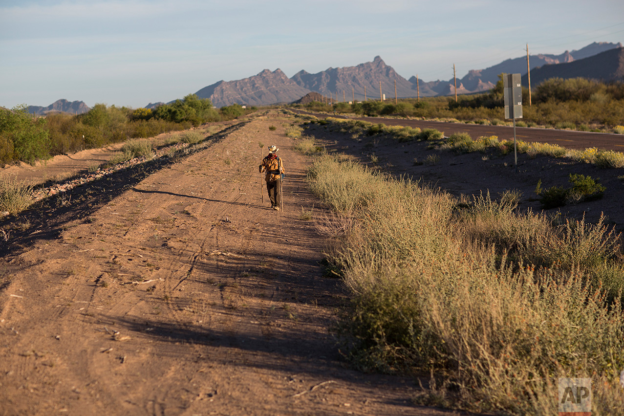 Mark Hainds, a 48-year-old junior community college forestry professor from Andalusia, Alabama, walks about 3 miles from his stopping point, near Why, Ariz., Monday, April 3, 2017. (AP Photo/Rodrigo Abd)