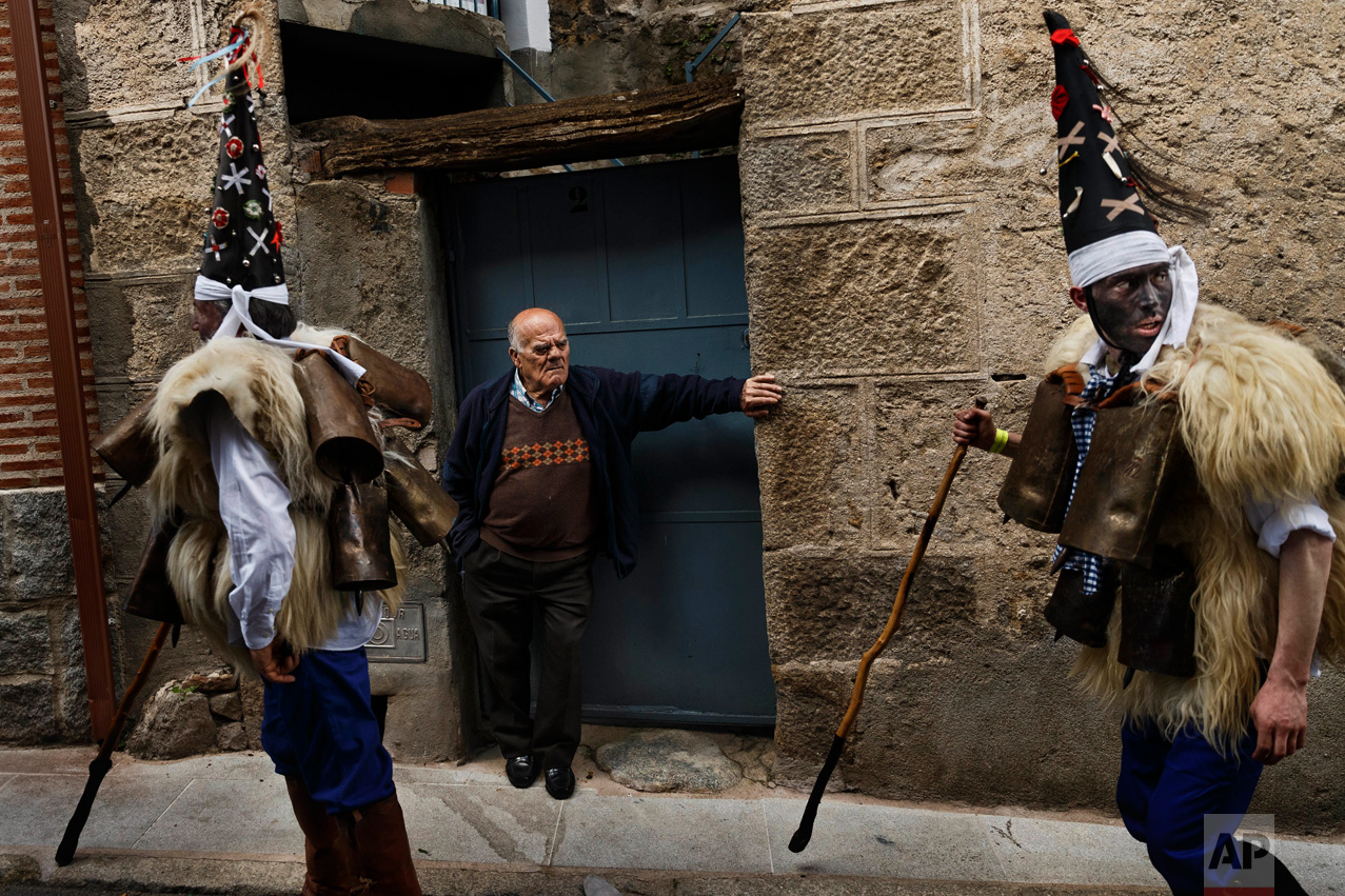 In this April 1, 2017 picture, a man looks as 'Zarramacos' dong their cowbells in a representation of the traditional carnival of La Vijanera de Silio during a gathering of different villages' carnival masks and characters, in Casavieja, Spain, Monday, April 3, 2017. (AP Photo/Daniel Ochoa de Olza)