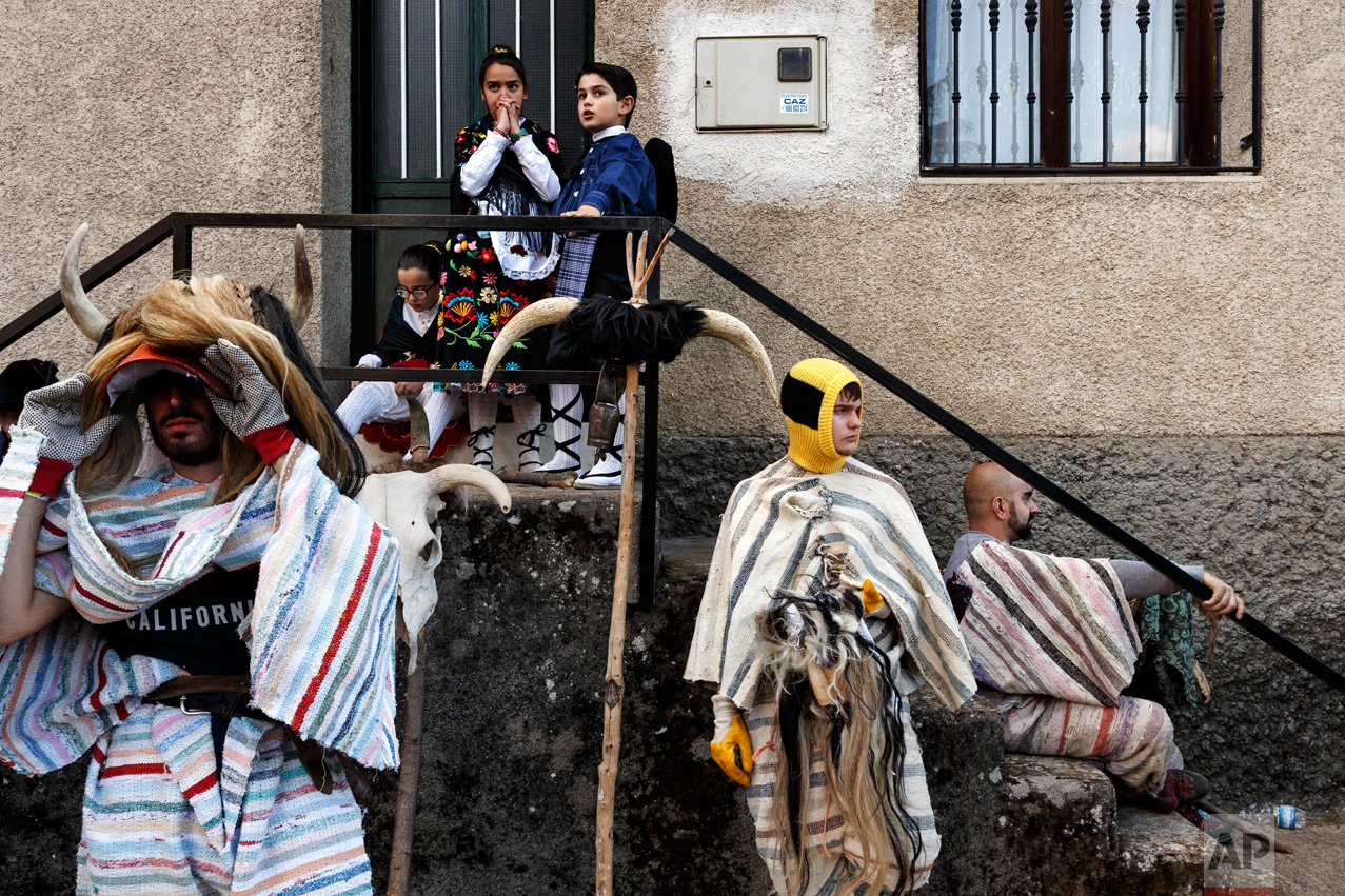 In this April 1, 2017 picture revelers from Navalosa village wearing the traditional 'Cucurrumacho' mask and outfit rest after a parade during a gathering of different villages' carnival masks and characters in the small village of Casavieja, Spain, Monday, April 3, 2017. (AP Photo/Daniel Ochoa de Olza)