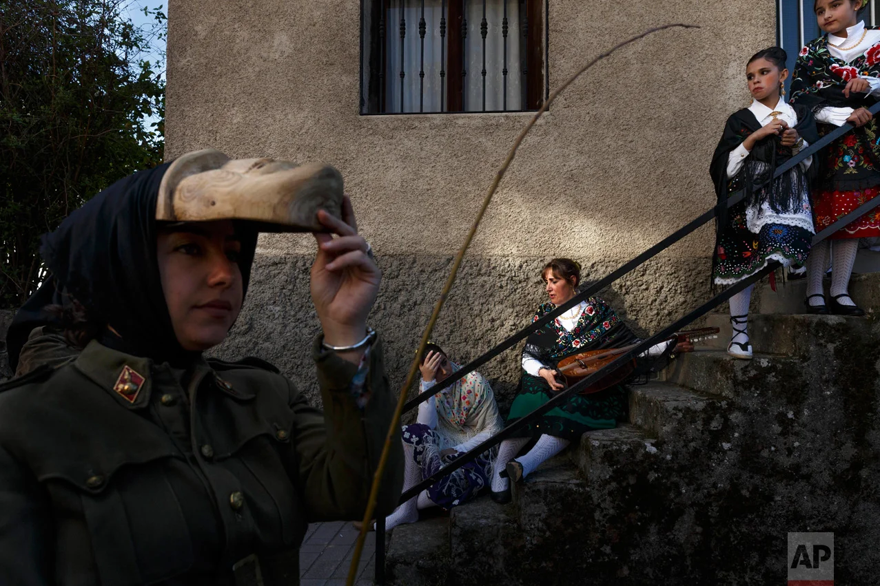 In this April 1, 2017 picture revelers from San Pedro Bernardo village wearing the traditional 'Machurrero' mask and outfit rest after a parade during a gathering of different villages' carnival masks and characters in the small village of Casavieja, Spain, Monday, April 3, 2017. (AP Photo/Daniel Ochoa de Olza)