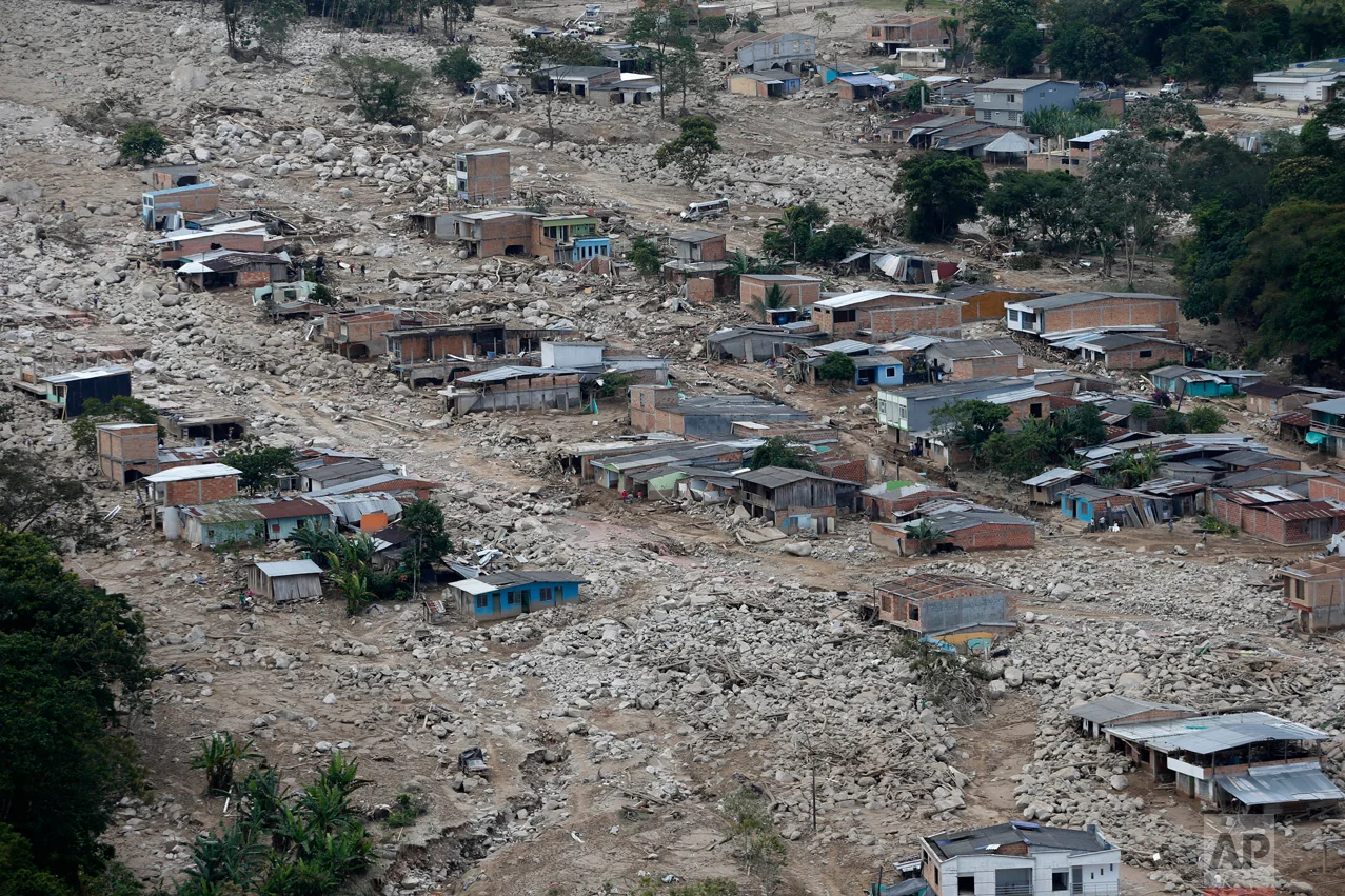 Boulders and debris surround homes on Tuesday, April 4, 2017, after rivers surrounding Mocoa, Colombia overflowed and sent a wall of water and debris surging through the city over the weekend. Authorities said hundreds were killed. (AP Photo/Fernando Vergara)