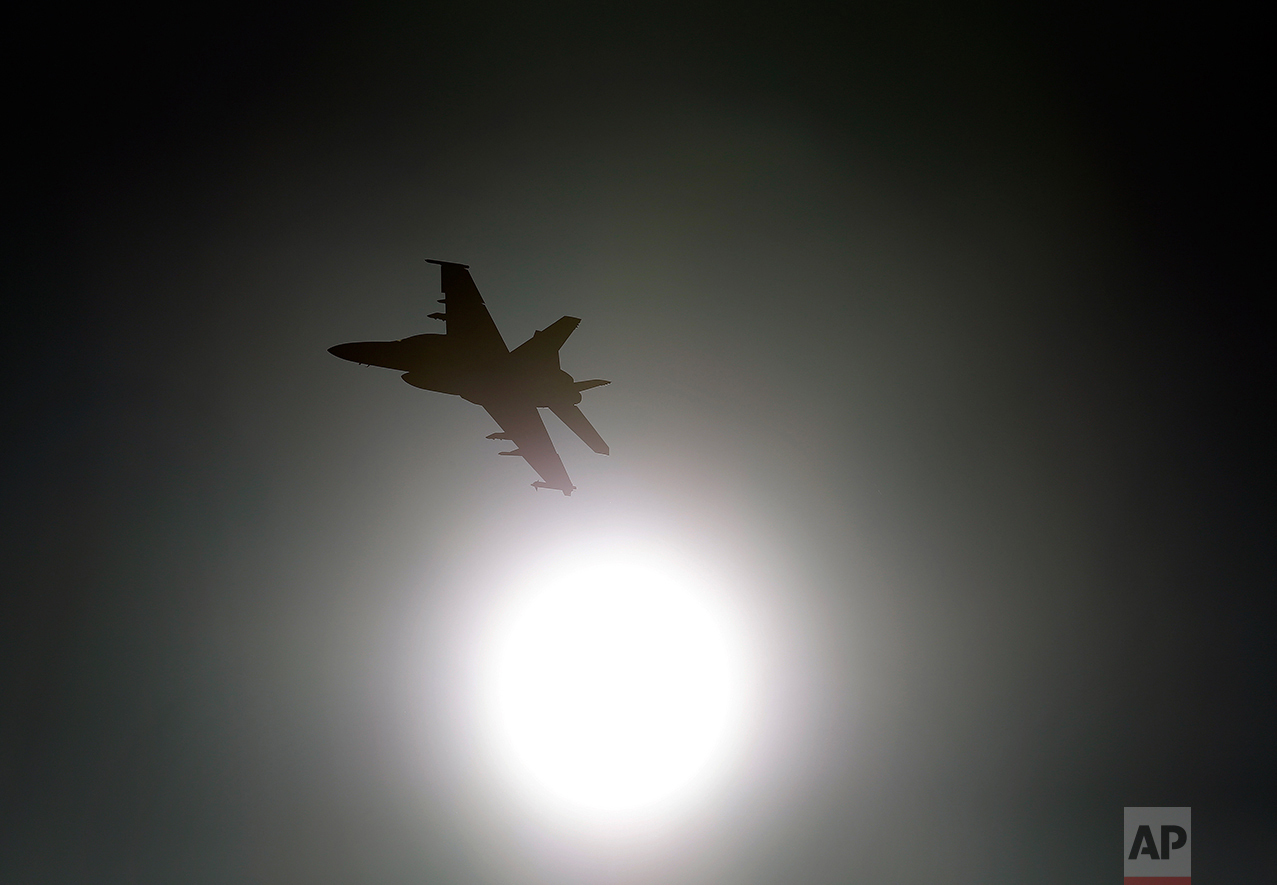 In this Feb. 28, 2017, photo, Thomas "Tom" P. McGee of the VX-9 Vampire squadron from Naval Air Weapons Station China Lake, flies an F/A-18E Super Hornet toward the sun over Death Valley National Park, Calif. Military jets roaring over national parks have long drawn complaints from hikers and campers. But in California's Death Valley, the low-flying combat aircraft skillfully zipping between the craggy landscape has become a popular attraction in the 3.3 million acre park in the Mojave Desert, 260 miles east of Los Angeles. (AP Photo/Ben Margot)