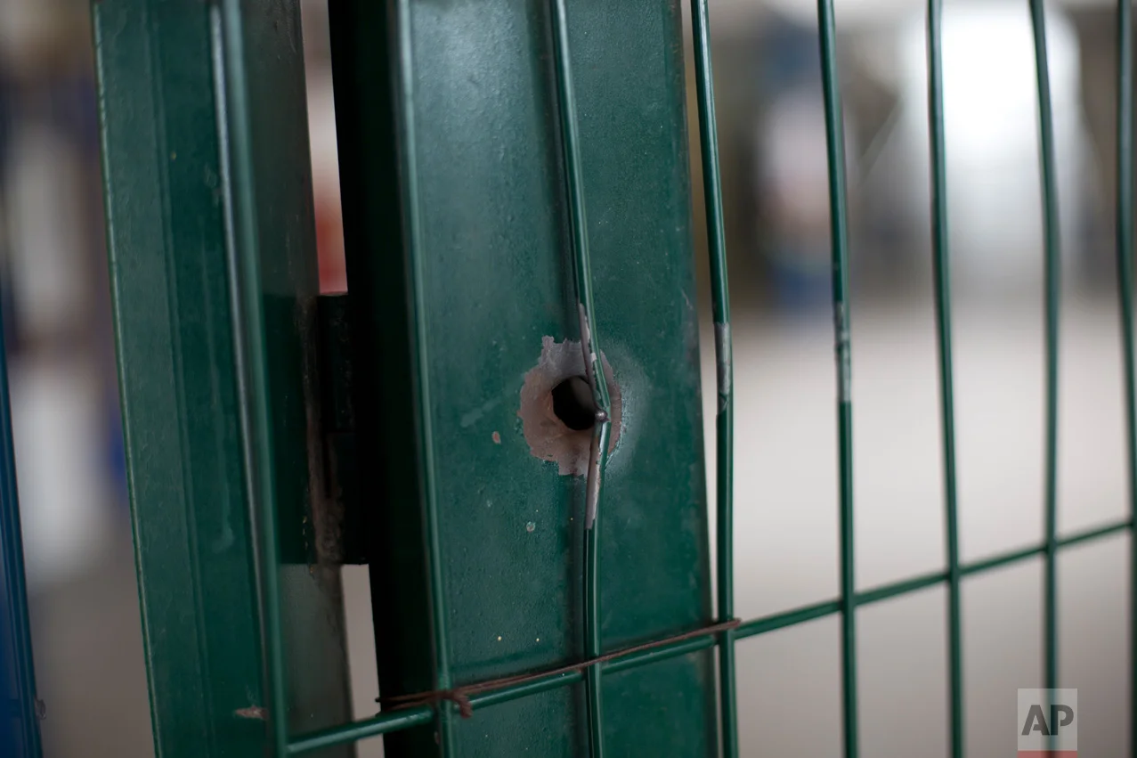 This April 12, 2017 photo shows a bullet hole on the front gate of a school in Acari, Rio de Janeiro, Brazil, where 13-year-old Maria Eduarda Conceicao was shot and killed when she was caught in the crossfire of a lengthy shootout between police and gangsters. (AP Photo/Silvia Izquierdo)