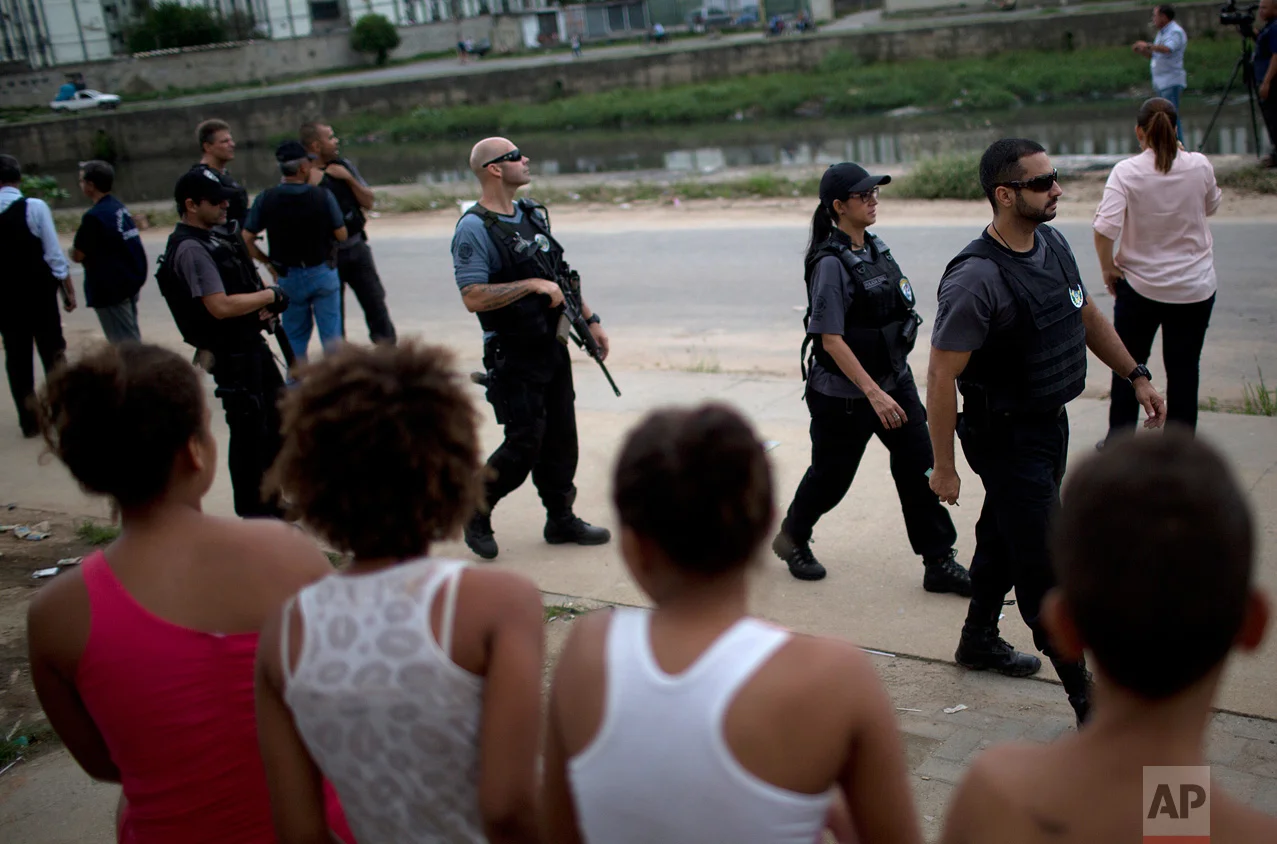 In this April 12, 2017 photo, police patrol an area near the school where a 13-year-old girl was shot and killed at a school in Acari, a poor northern neighborhood in Rio de Janeiro. Maria Eduarda Conceicao was hit by several rounds at the school entrance on March 30 as she walked to the water fountain. She was caught in the crossfire of a lengthy shootout between police and gangsters. (AP Photo/Silvia Izquierdo)
