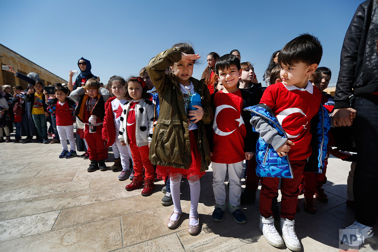 In this March 29, 2017 photo, schoolchildren during a visit at the mausoleum of Mustafa Kemal Ataturk, the founder of modern Turkey watch the change of the honour guard in Ankara, Turkey. The legacy of the man whose surname means "father of Turks" was one of a modern, secular, western-leaning Turkey. But the personality cult that grew around him has very gradually been fading as current President Recep Tayyip Erdogan, in power since 2003 as alternately prime minister and president, has harked back to the glory days of the height of the Ottoman Empire to whip up patriotic sentiment. (AP Photo/Lefteris Pitarakis)