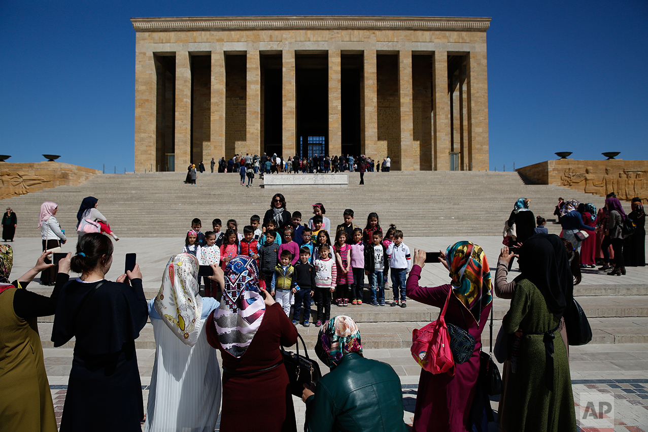 In this March 29, 2017 photo, teachers take pictures of schoolchildren during a visit at the mausoleum of Mustafa Kemal Ataturk, the founder of modern Turkey in Ankara, Turkey. The legacy of the man whose surname means "father of Turks" was one of a modern, secular, western-leaning Turkey. But the personality cult that grew around him has very gradually been fading as current President Recep Tayyip Erdogan, in power since 2003 as alternately prime minister and president, has harked back to the glory days of the height of the Ottoman Empire to whip up patriotic sentiment. (AP Photo/Lefteris Pitarakis)