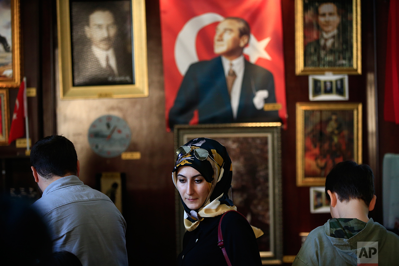 In this March 29, 2017 photo, visitors of the mausoleum of Mustafa Kemal Ataturk, the founder of modern Turkey, visit the museum shop, in Ankara, Turkey. The legacy of the man whose surname means "father of Turks" was one of a modern, secular, western-leaning Turkey. But the personality cult that grew around him has very gradually been fading as current President Recep Tayyip Erdogan, in power since 2003 as alternately prime minister and president, has harked back to the glory days of the height of the Ottoman Empire to whip up patriotic sentiment. (AP Photo/Lefteris Pitarakis)
