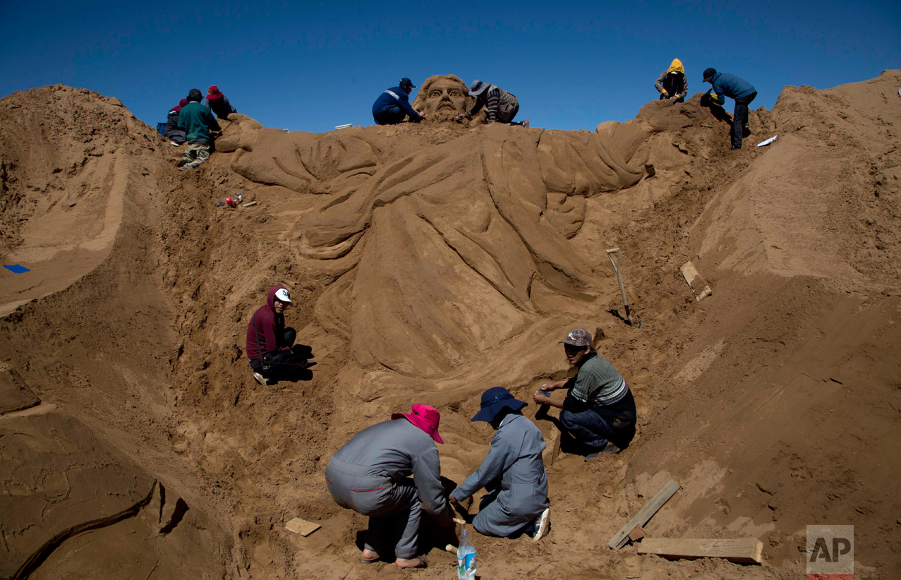 Artists work on a sand sculpture depicting Jesus Christ, during Holy Week celebrations in Arenal de Cochiraya, on the outskirts of Oruro, Bolivia, Friday, April 14, 2017. Two hundred artists gathered for the annual Good Friday event in the highland region, building sand sculptures based on the parables of Jesus. (AP Photo/Juan Karita)