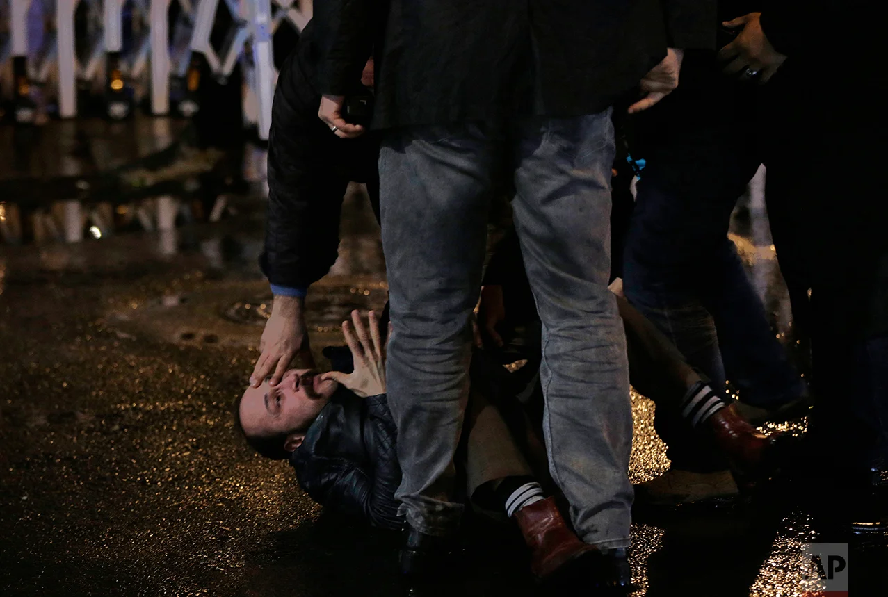 Riot police officers detain a protester outside the Supreme Electoral Board in Ankara, Turkey, late Sunday, April 16, 2017. Turkish President Recep Tayyip Erdogan won a historic referendum Sunday that will greatly expand the powers of his office, although opposition parties questioned the outcome and said they would challenge the results.(AP Photo/Burhan Ozbilici)